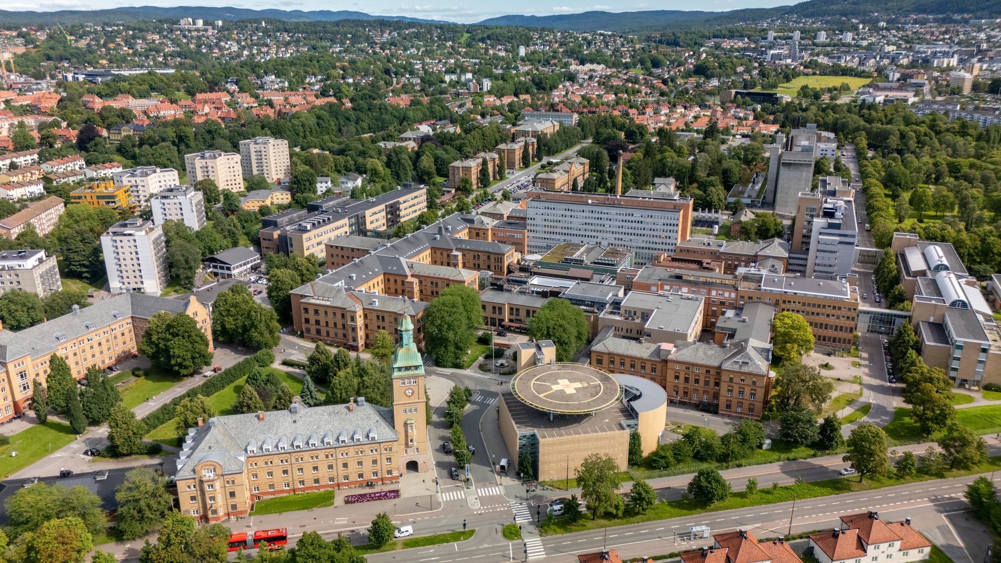 Flyfoto over Ullevål sykehus i Oslo med omkringliggende bebyggelse og parkområder. (Bildebeskrivelsen er laget av en KI-tjeneste)