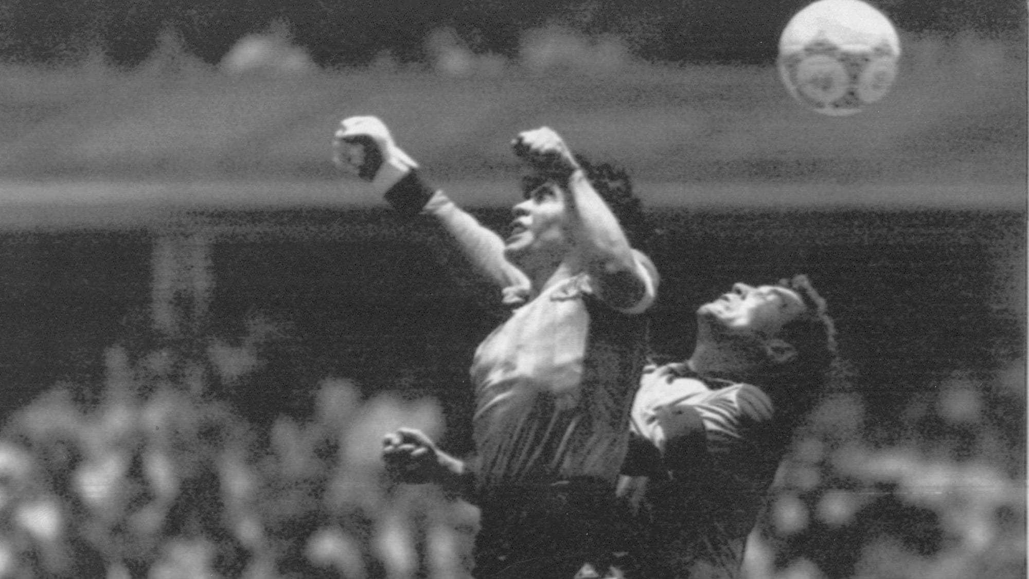 Diego Maradona i en luftduell med keeper Peter Shilton under VM i 1986. Sort-hvitt fotografi. (Bildebeskrivelsen er laget av en KI-tjeneste)