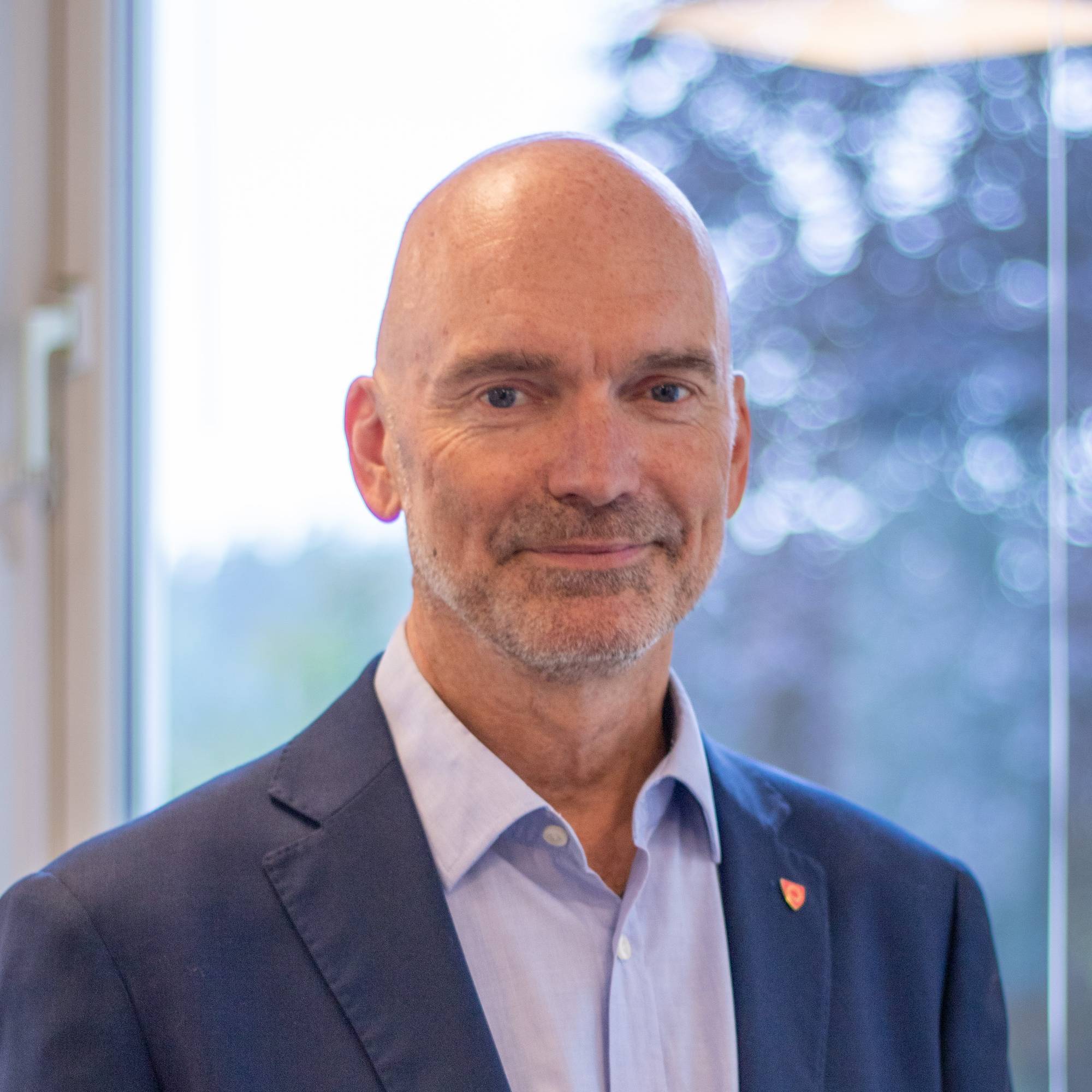 Portrett av en mann med skjegg i blå dressjakke