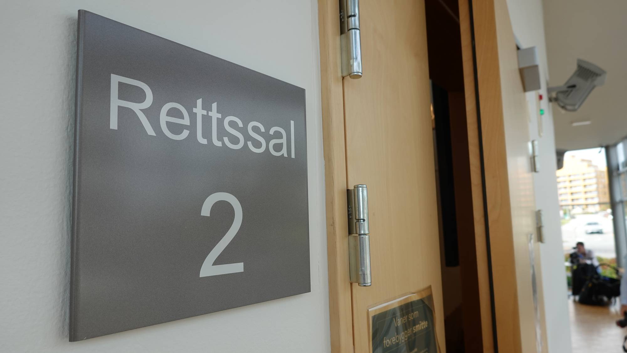 Skilt med teksten Rettssal 2 på veggen ved inngangen til en rettssal. (Bildebeskrivelsen er laget av en KI-tjeneste)