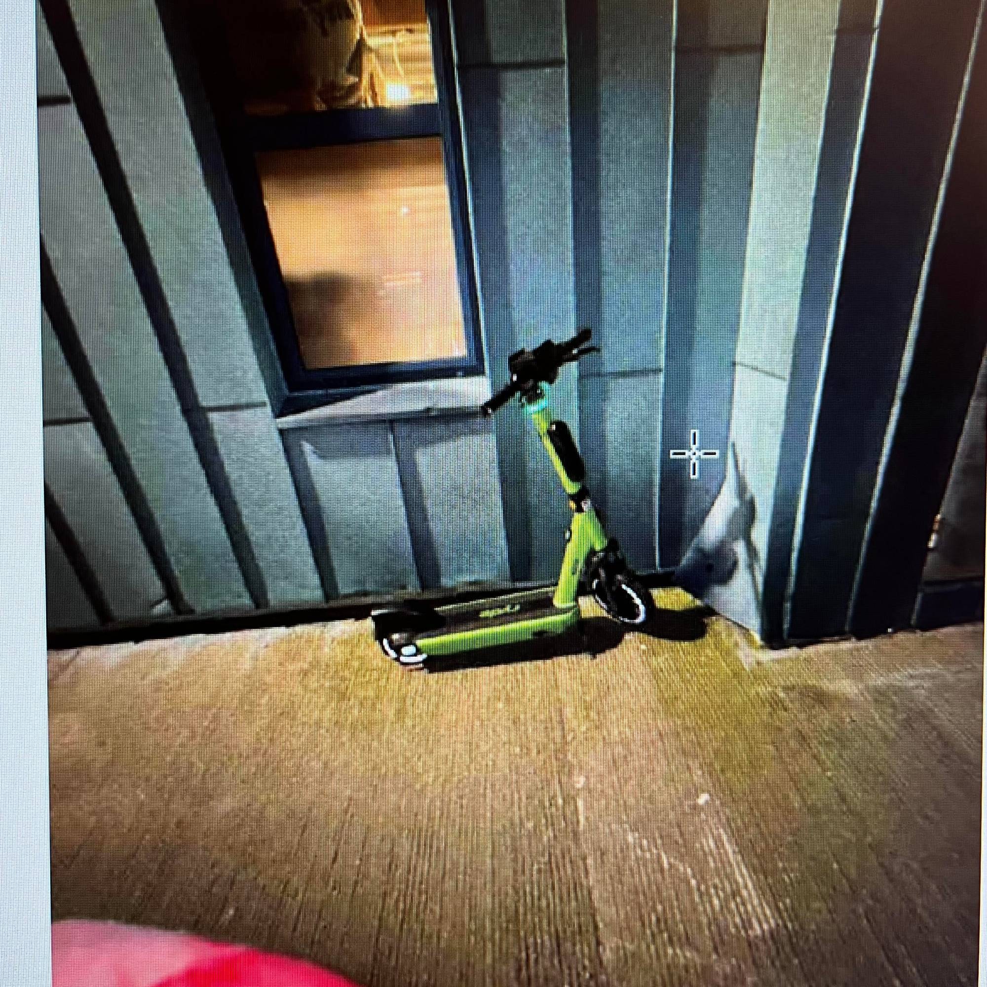 En elsparkesykkel står lent inntil en vegg ved Legevakten i Bergen. 