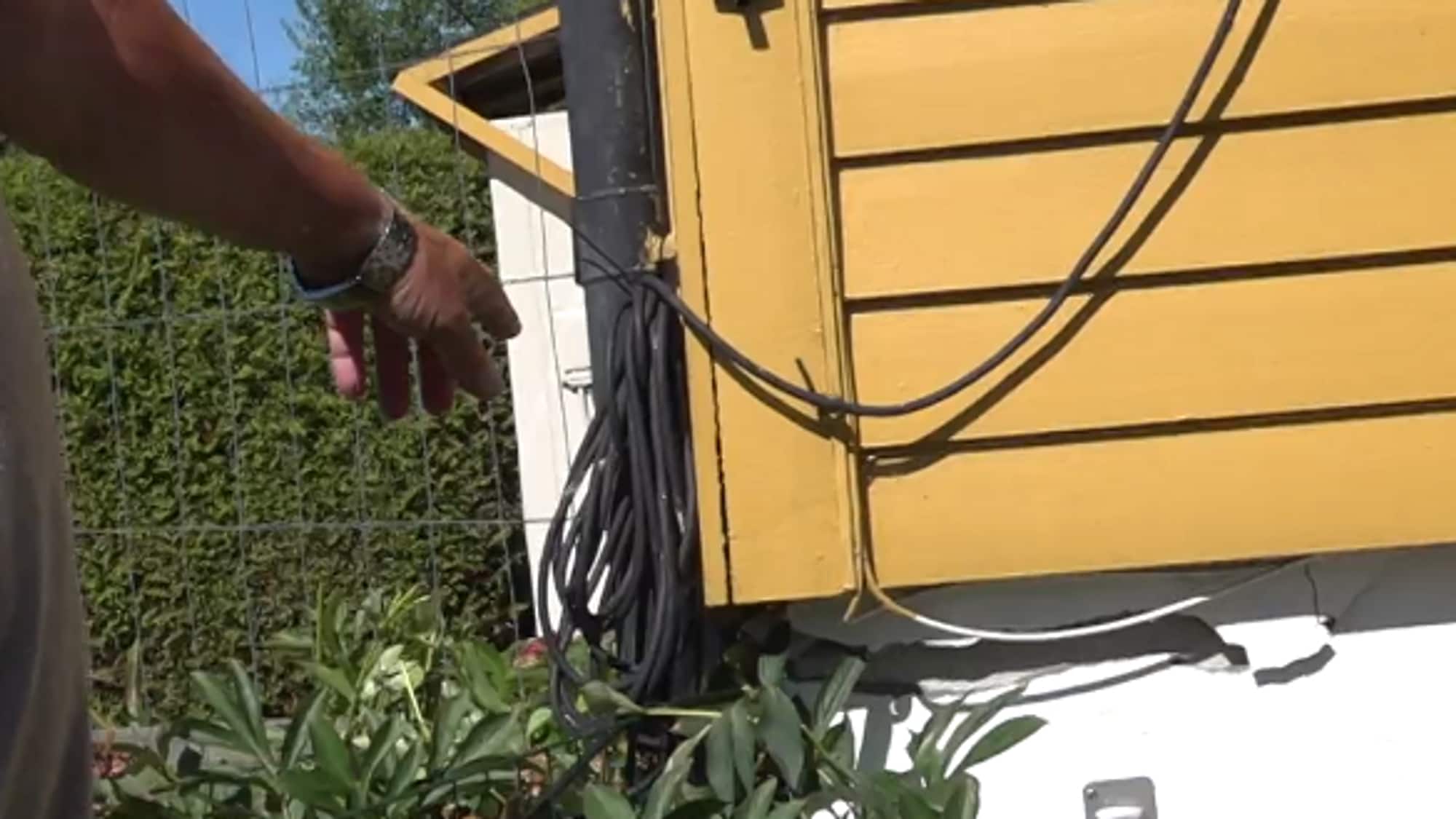 Paul fra Råde peker på ødeleggelsene på muren på huset etter at en bil kræsjet inn i huset deres. Muren er smuldret opp. 