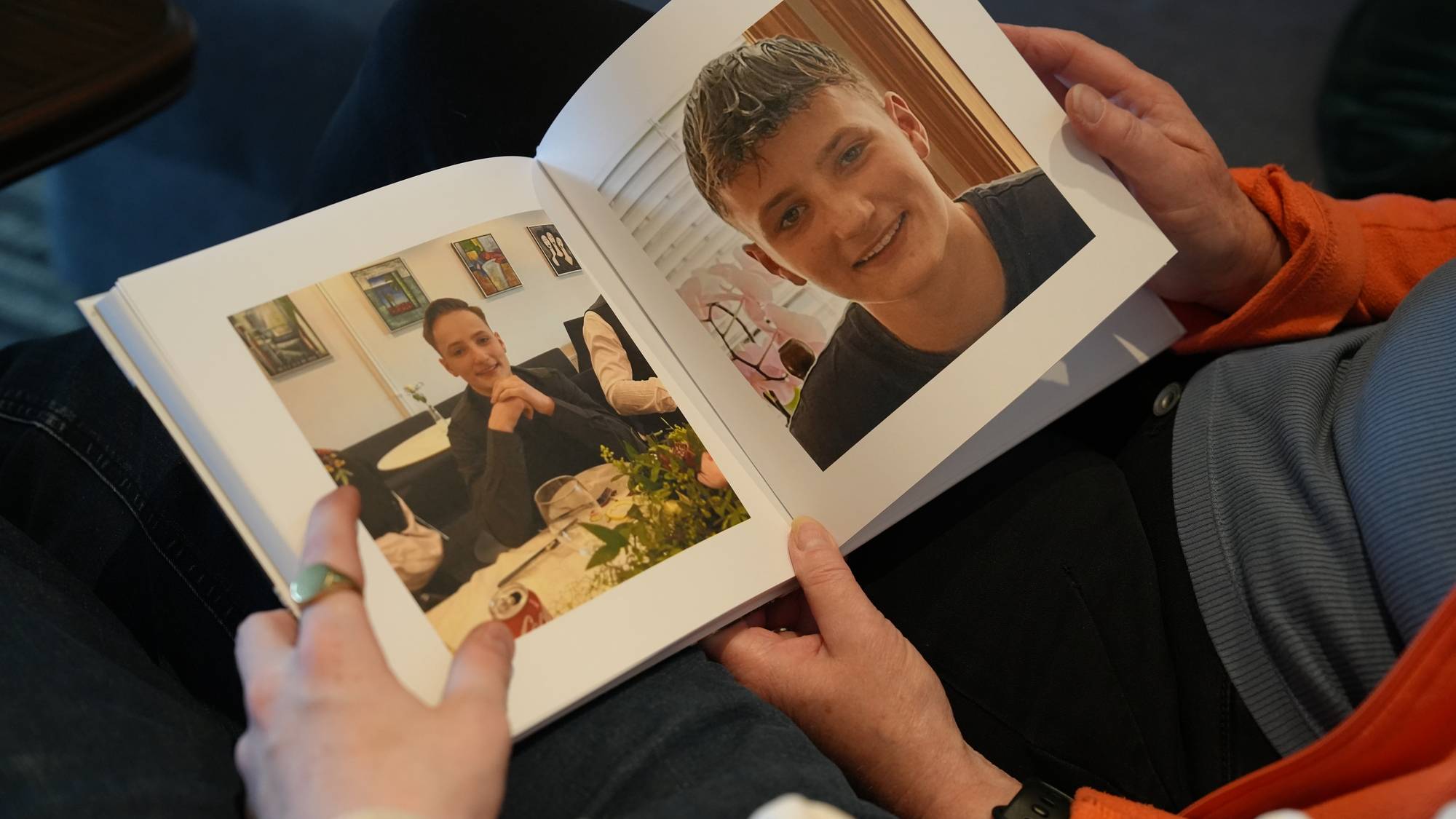 Nærbilde av en oppslått bok som viser to bilder av en ung gutt. På det ene bildet sitter han i en sofa, og på det andre smiler han til kamera.