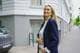 Julianne Kyoo-Ree Eikrem / NRK En kvinne i mørk blazer går ute. Bak henne står en bil parkert ved en bygning. En mann går på fortauet i bakgrunnen. (Bildebeskrivelsen er laget av en KI-tjeneste)