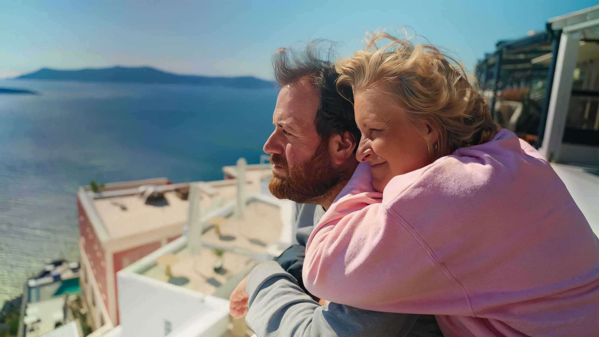 Tuva og Ronny i Hellas. Tuva lener seg på Ronnys skuldre, og de ser begge smilende utover utsikten. Havet er blått, og det er fin sol. 