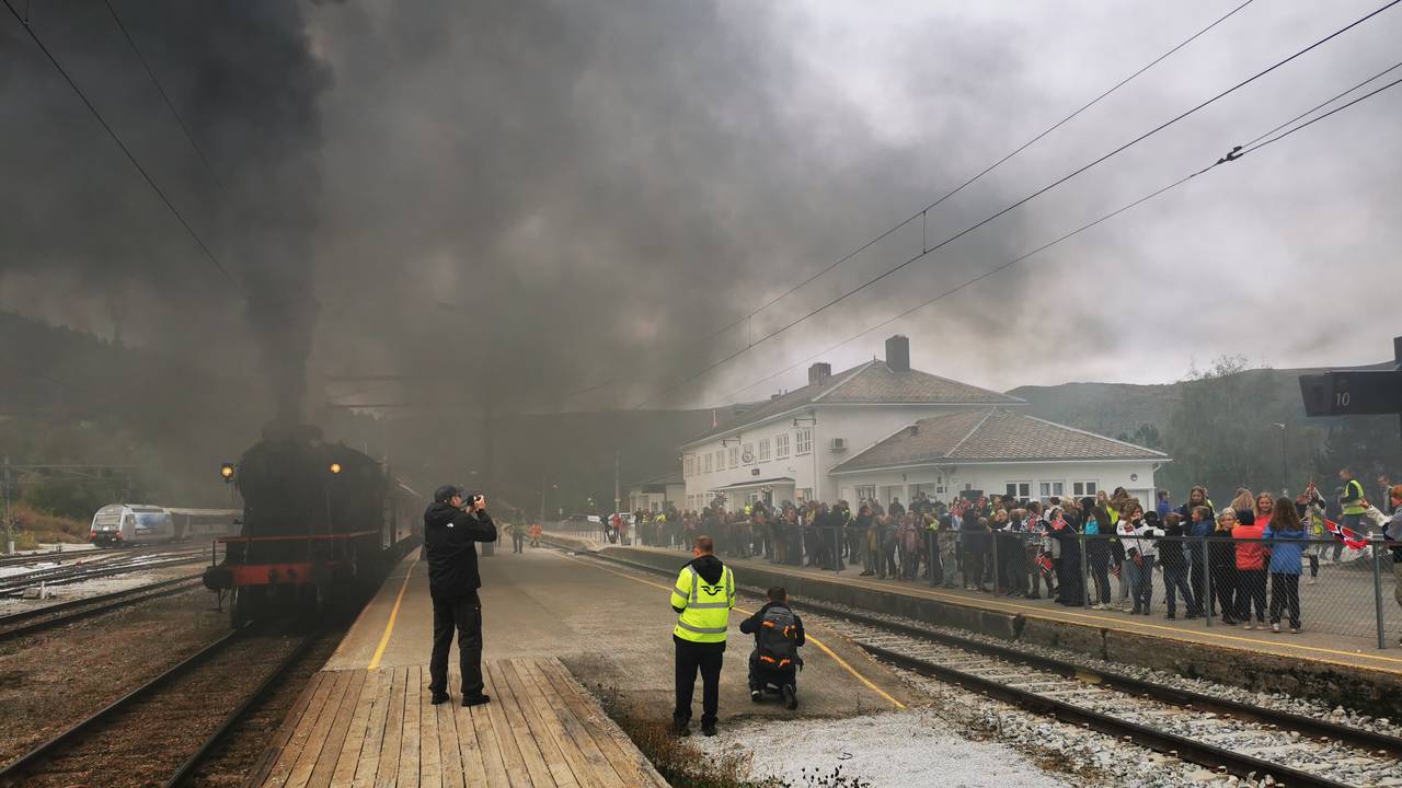Røyken ligger tjukt på Dombås stasjon da damptoget forlater stasjonen.