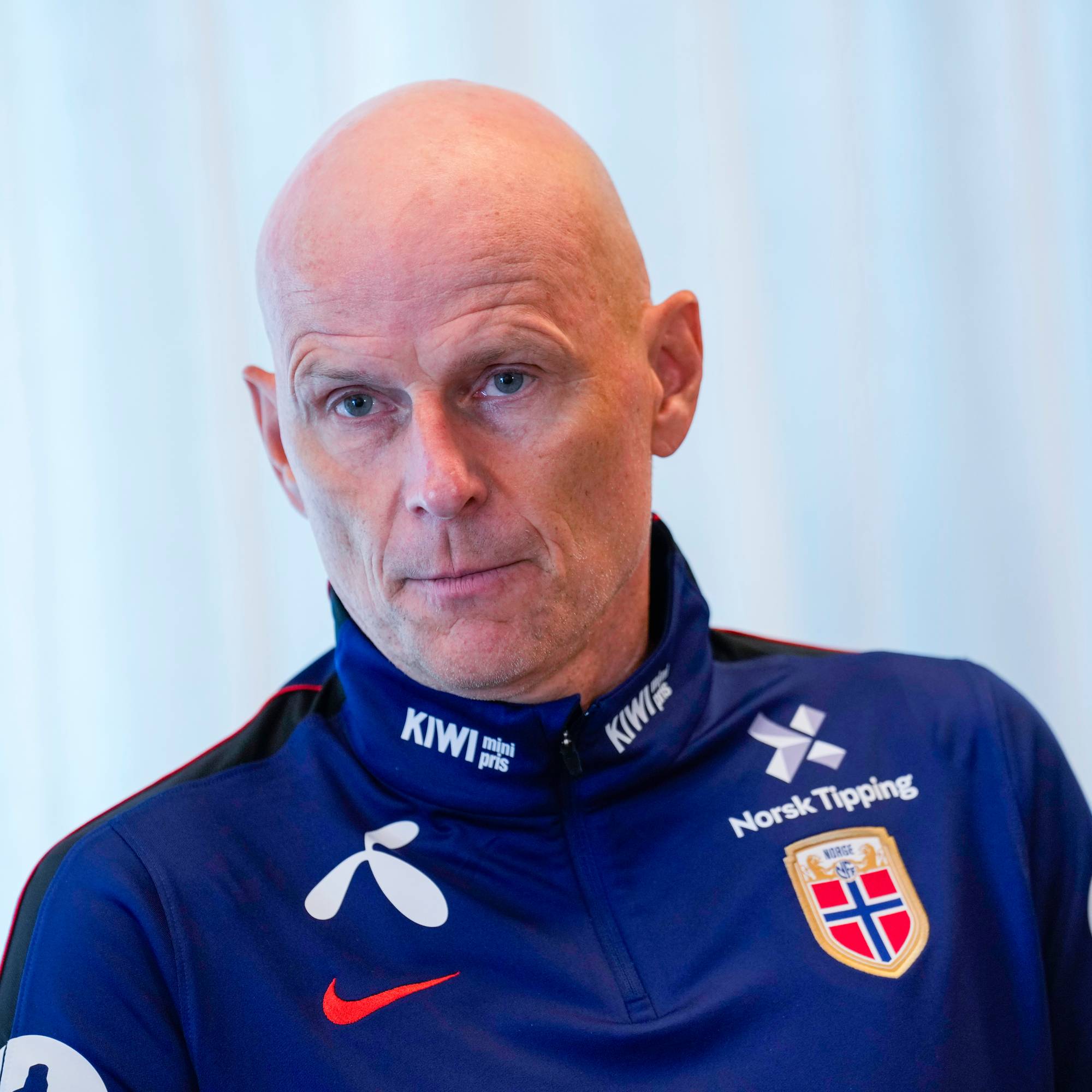 Ståle Solbakken i blå landslagsjakke foran en lys bakgrunn. (Bildebeskrivelsen er laget av en KI-tjeneste)