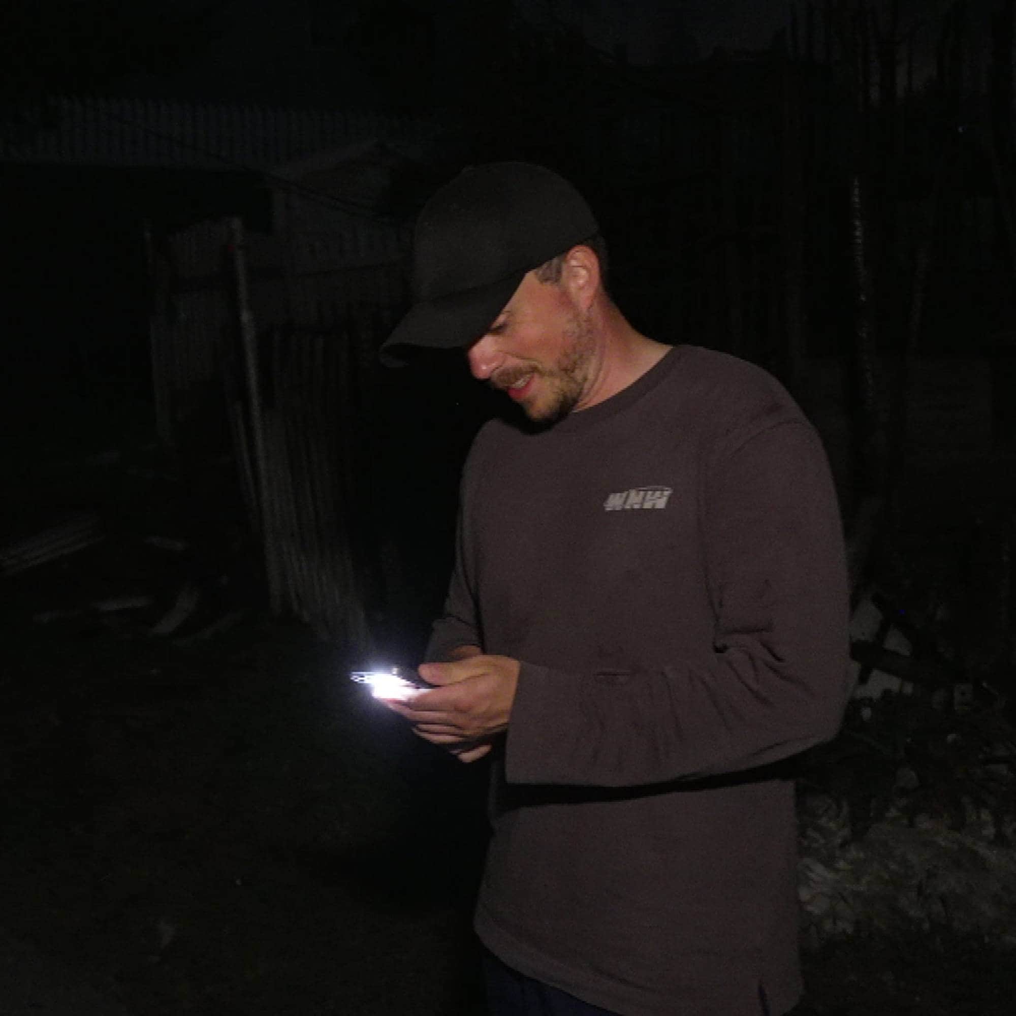 Mann med caps og mobil i hånden. 