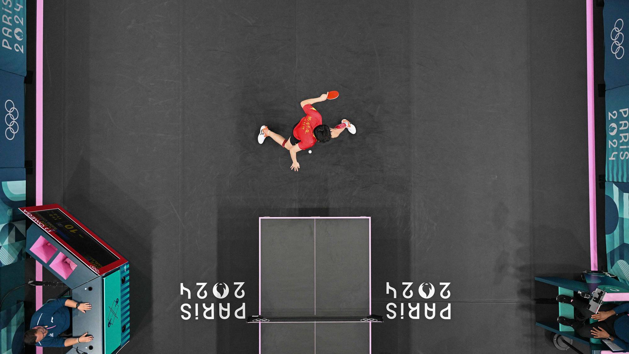 Bordtennisspiller i aksjon sett ovenfra under OL i Paris 2024. (Bildebeskrivelsen er laget av en KI-tjeneste)