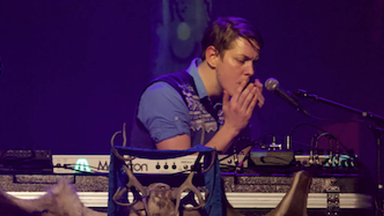 Keyboardisten spiller munnharpe i det lilla scenelyset