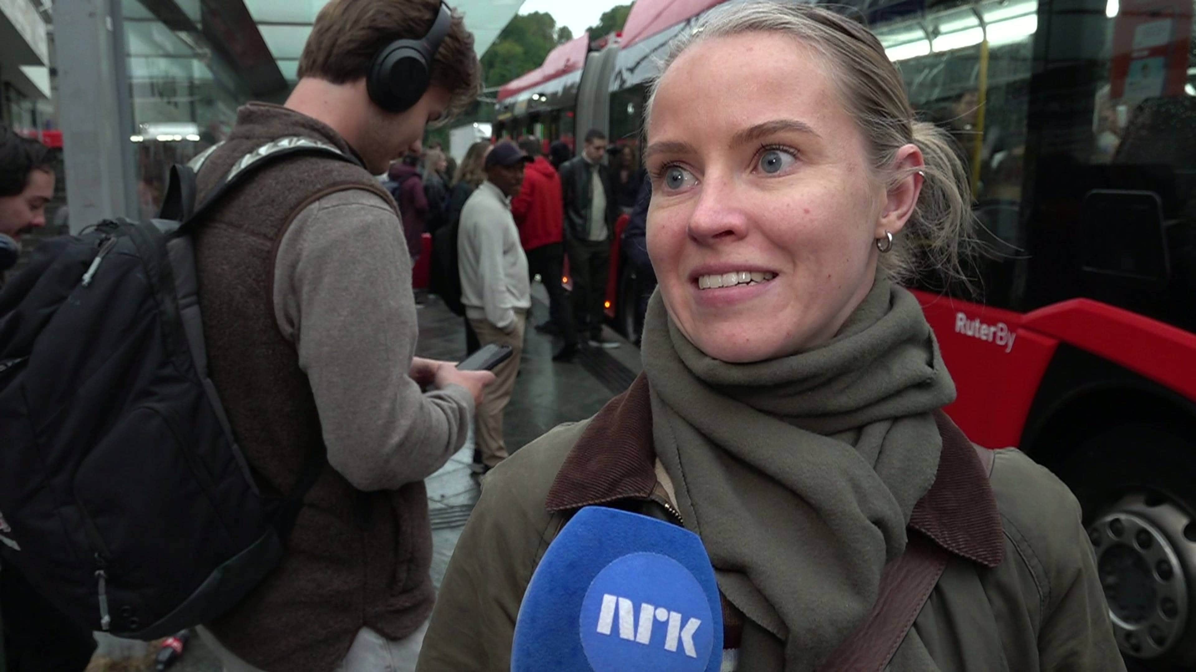 Kvinne med oppbundet hår og stort grønt skjerf rundt halsen.