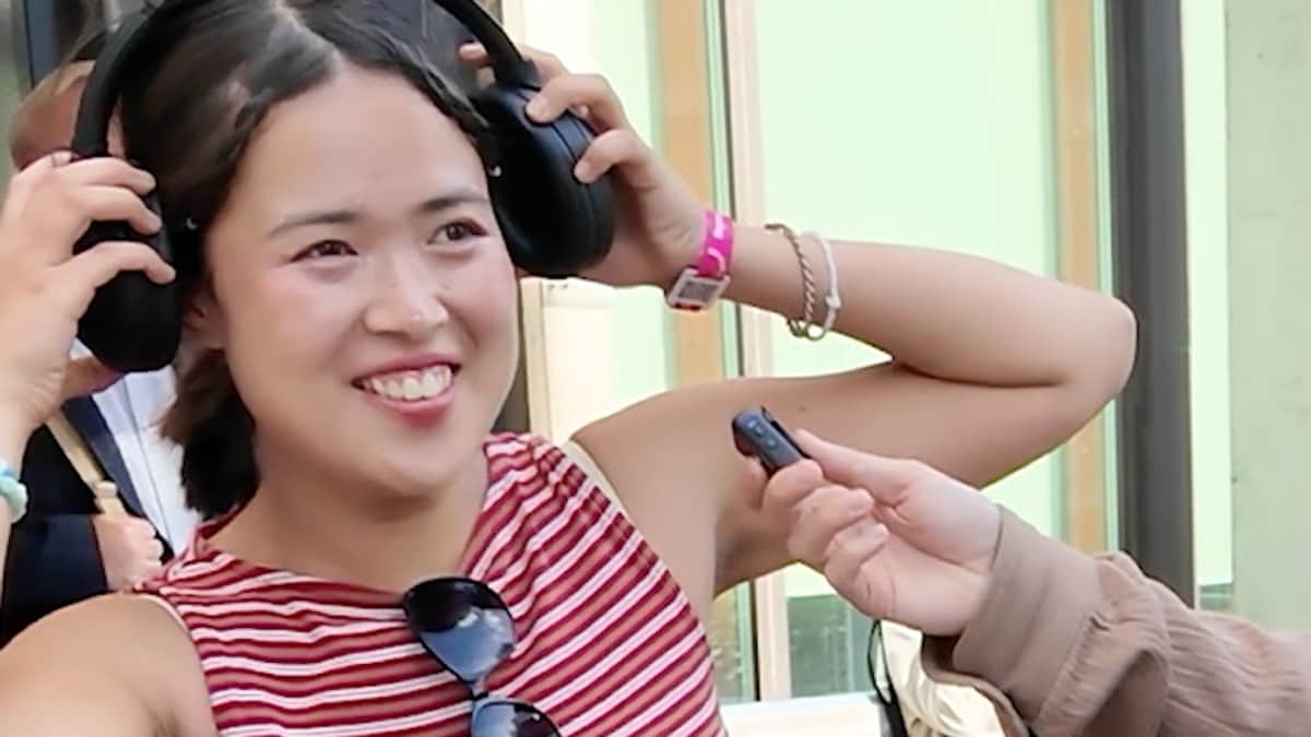En ung kvinne ler og hører på musikk
