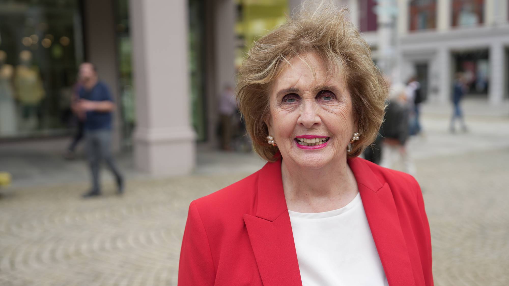 Trude Drevland, kledd i raudt, på Torgallmenningen i Bergen. 