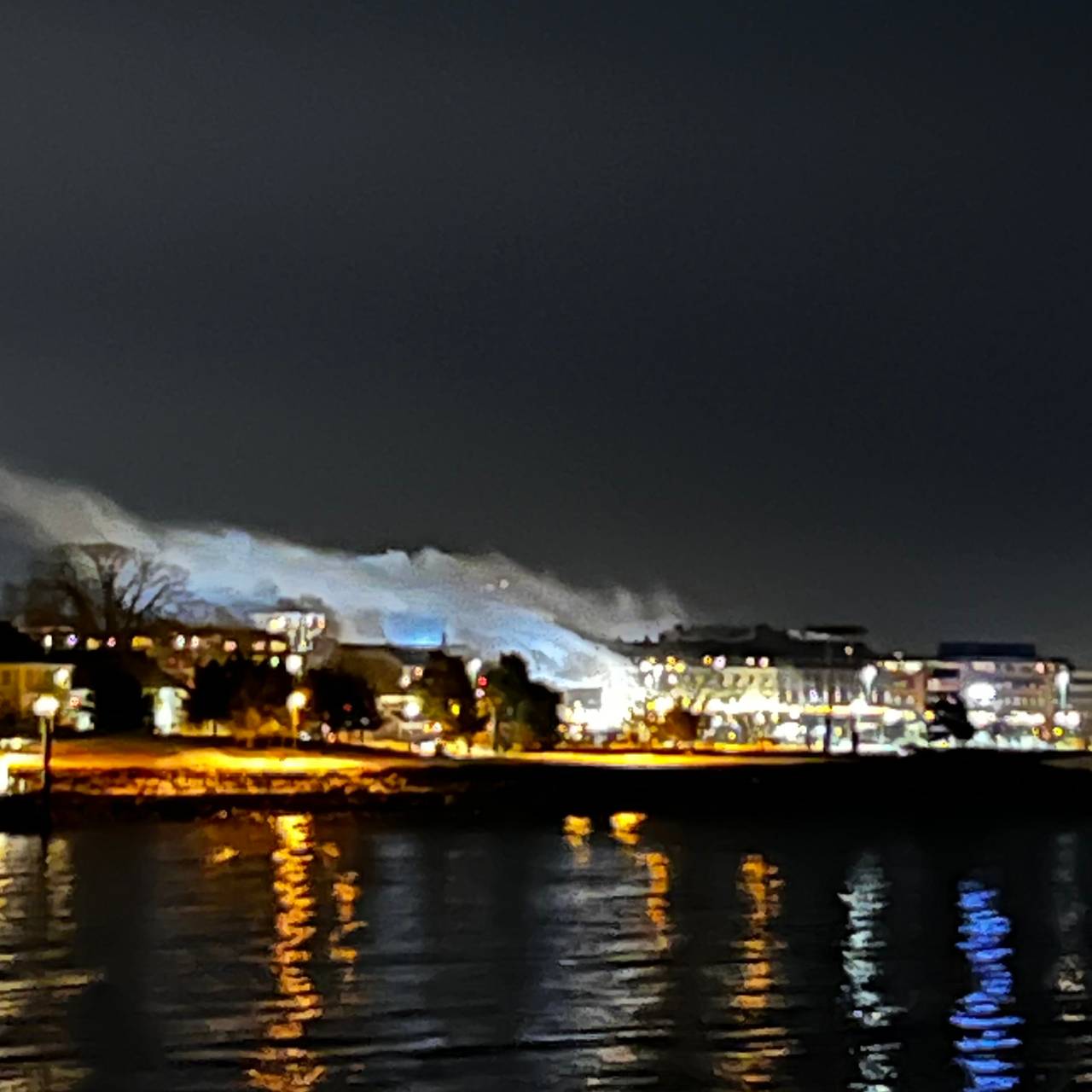 Brann i Gisetgården i Hamar, sett fra Mjøsa. Røyken stiger opp over byen.