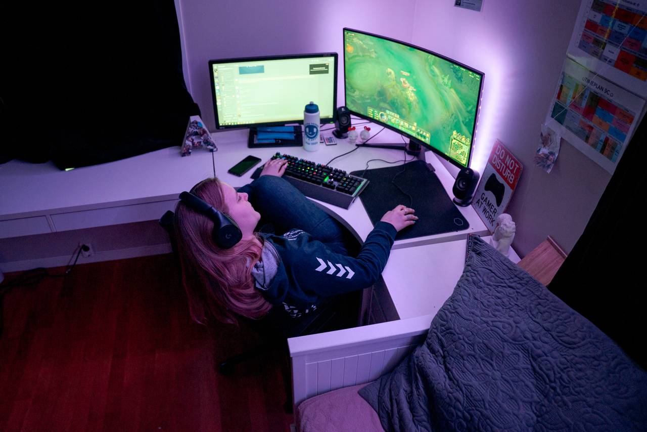 Anna Redalen Søfting (14) lener seg bakover på stolen mens hun spiller e-sport på datamaskinen sin.