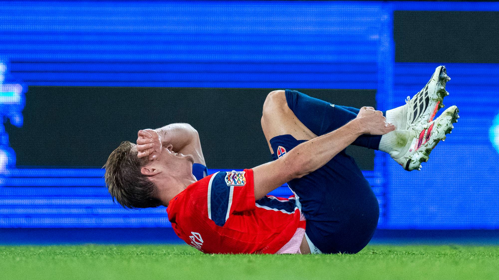 fotballspiller som holder seg til ankel