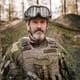 David Luttu Carr / Forsvarsmakten En mann i militæruniform og hjelm, samt briller på hodet og vest.