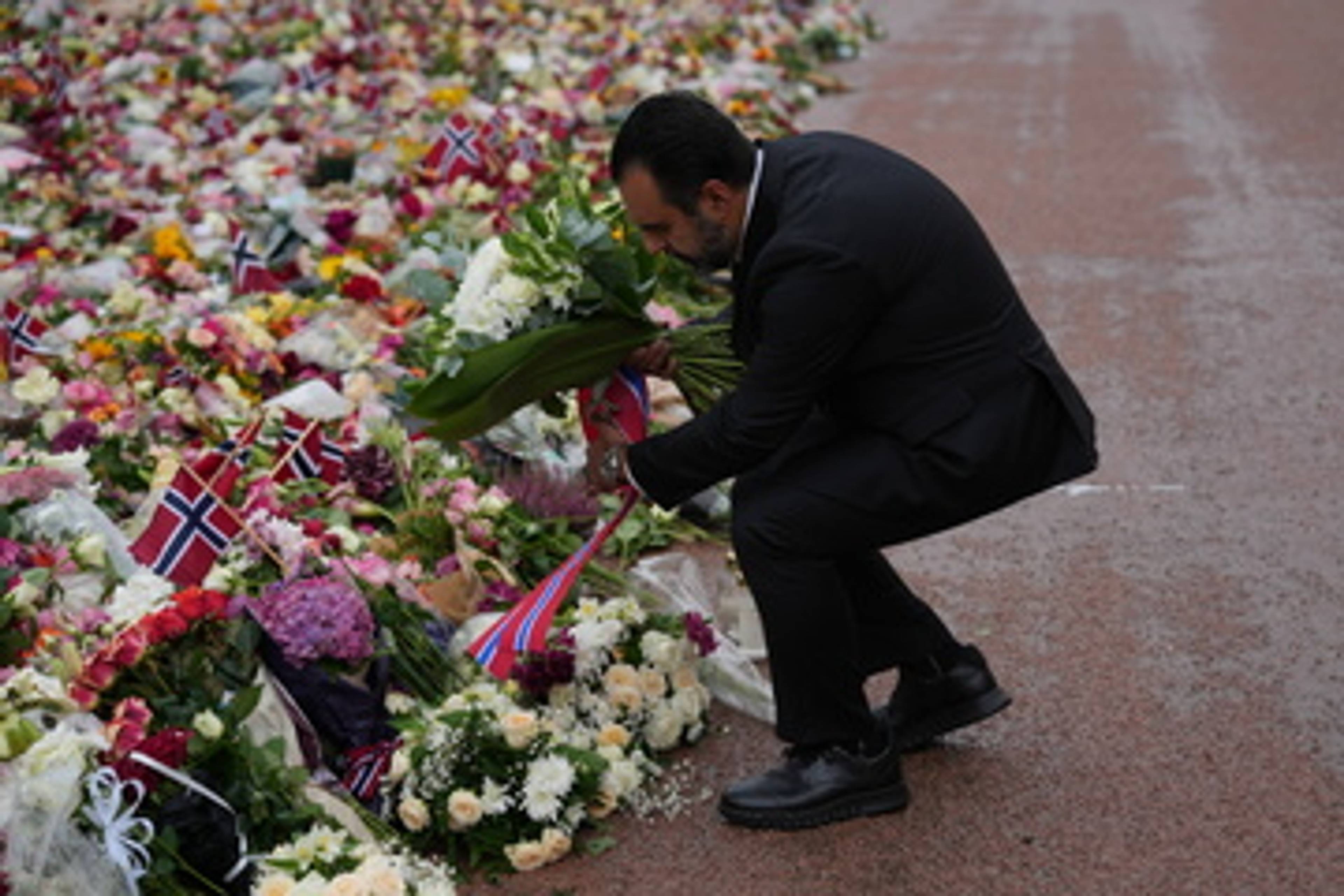 Masud Gharahkhani  legger ned blomster foran folkemengden på slottsplassen
