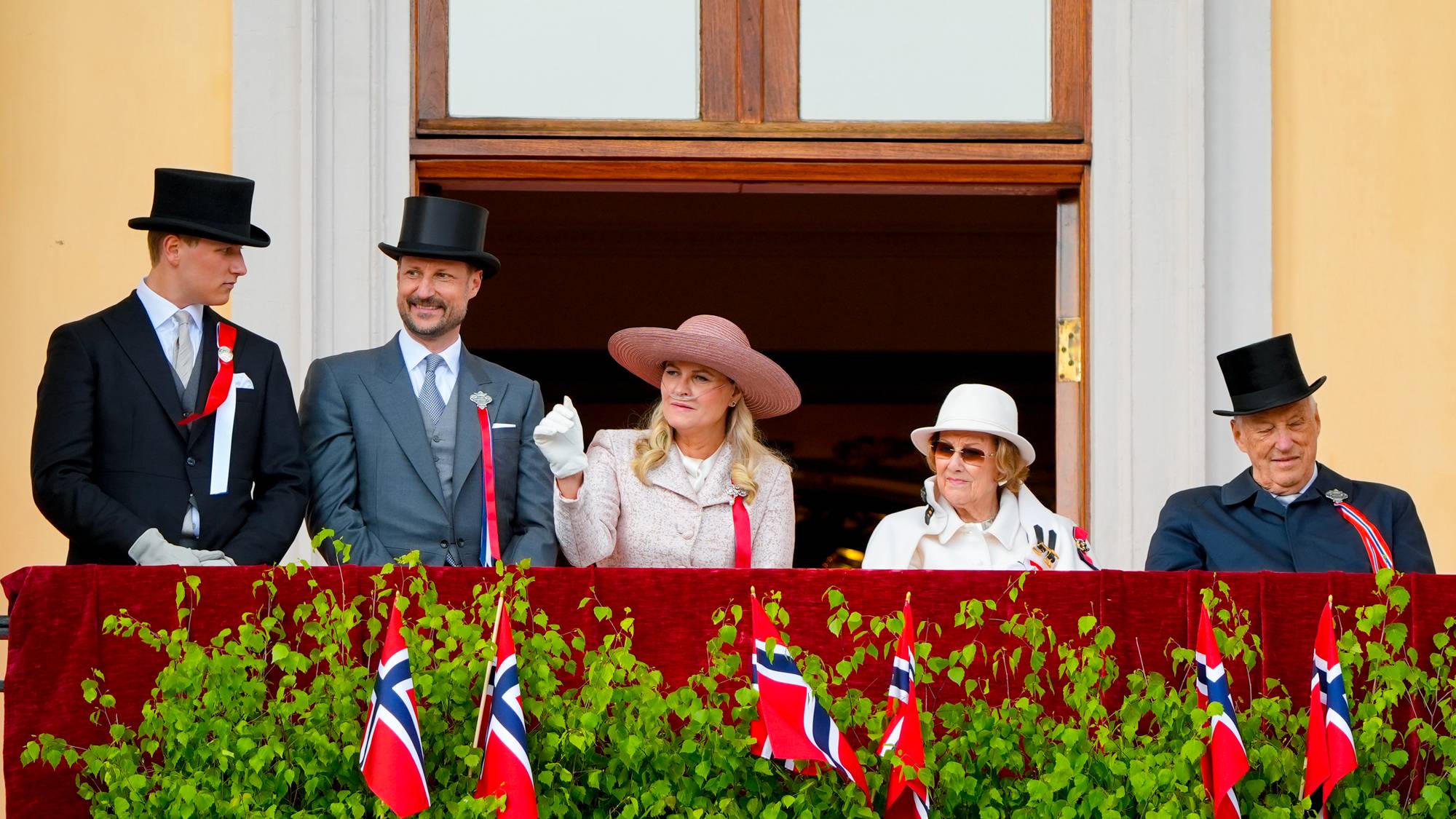 Kongefamilien hilser barnetoget i Oslo fra Slottsbalkongen på 17. mai 2026