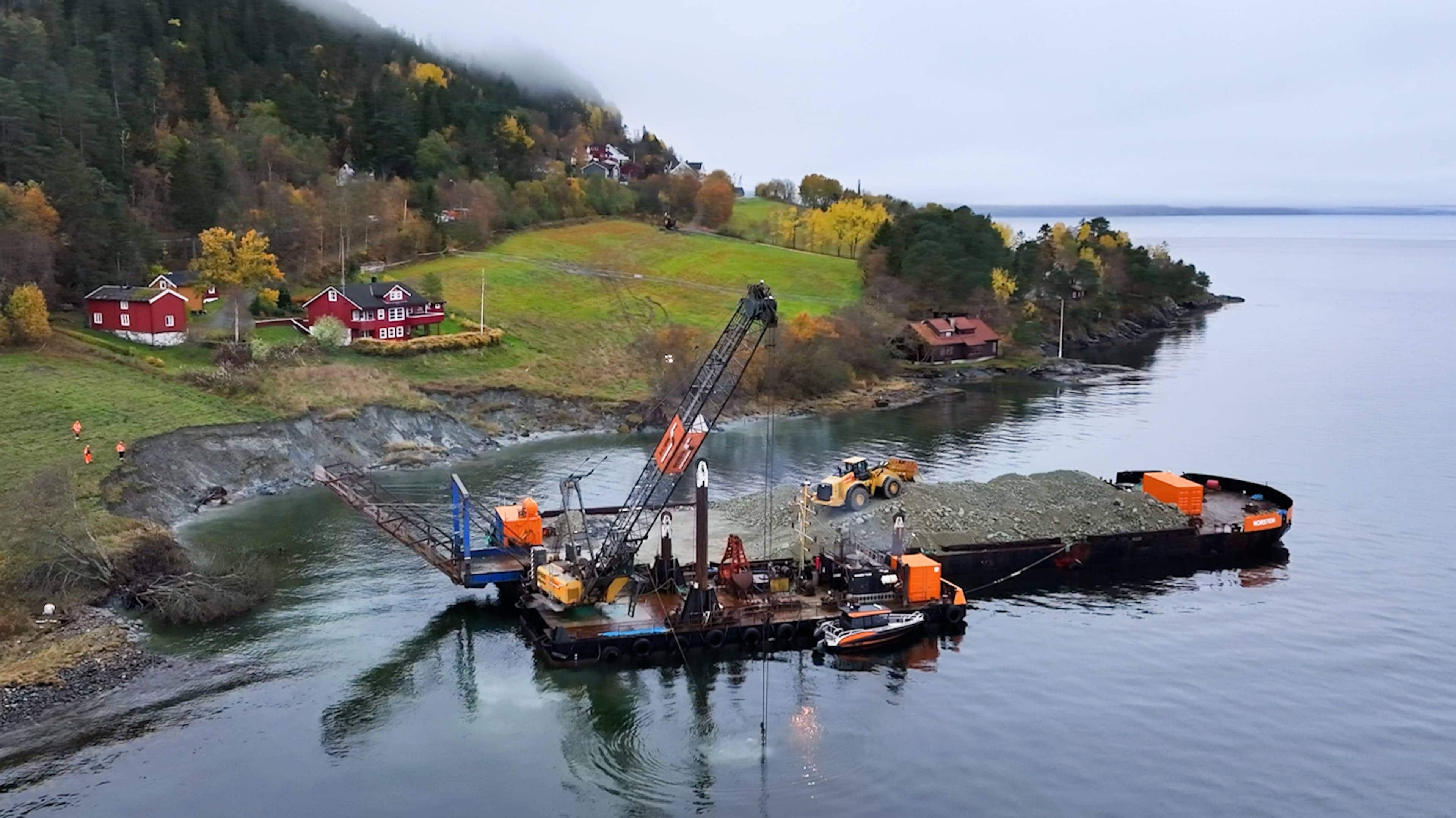 Ein lekter på sjøen med ein gravemaskin.