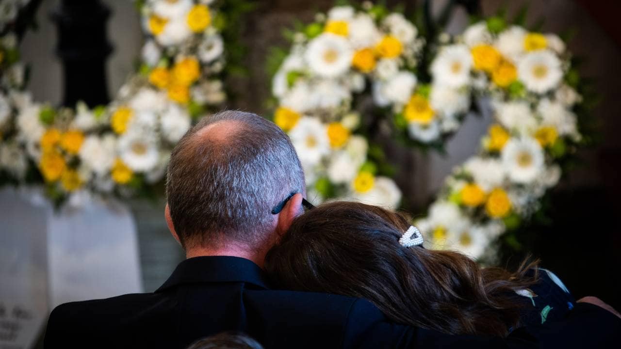 Foreldrene til Cecilie lener hodene inntil hverandre. I bakgrunnen er de gule blomstene