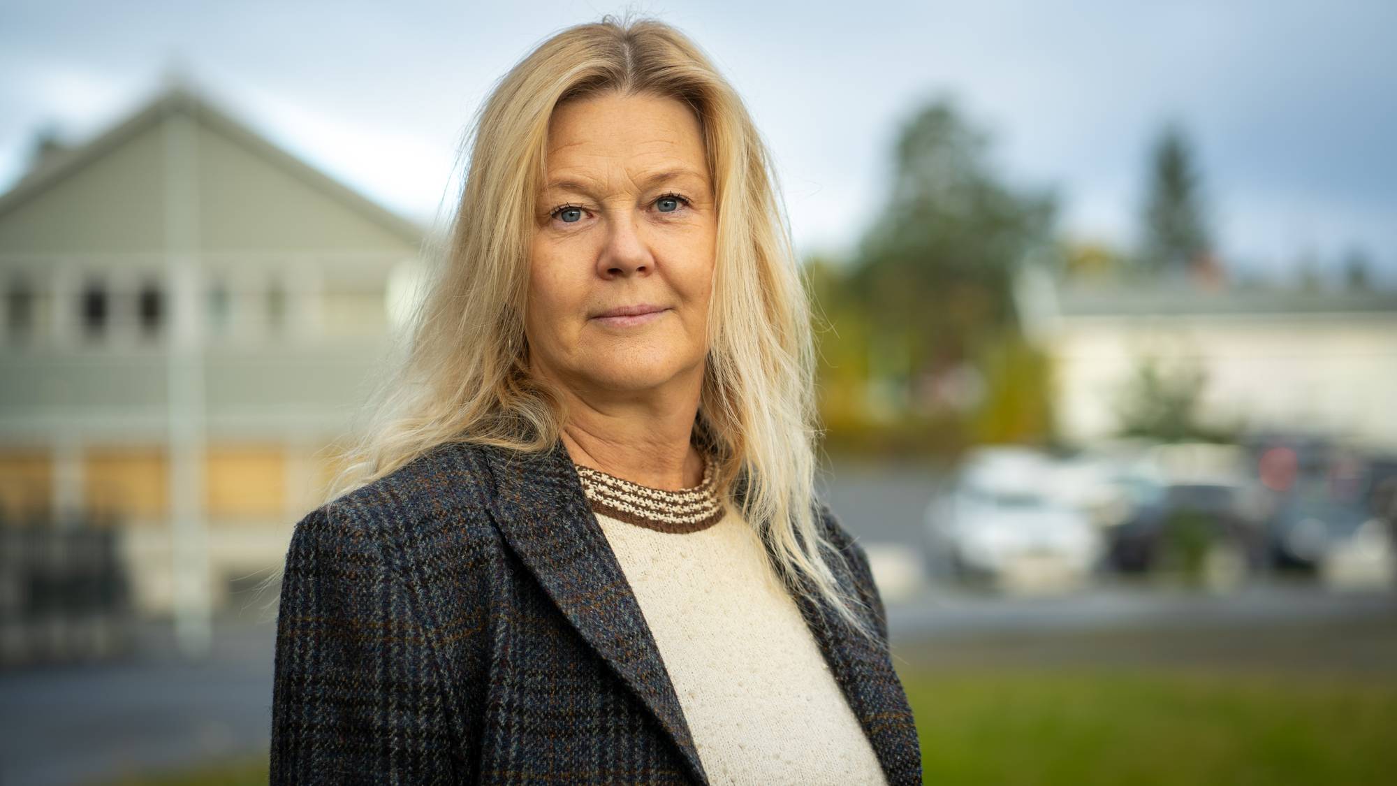 Kvinne med lyst hår står ute