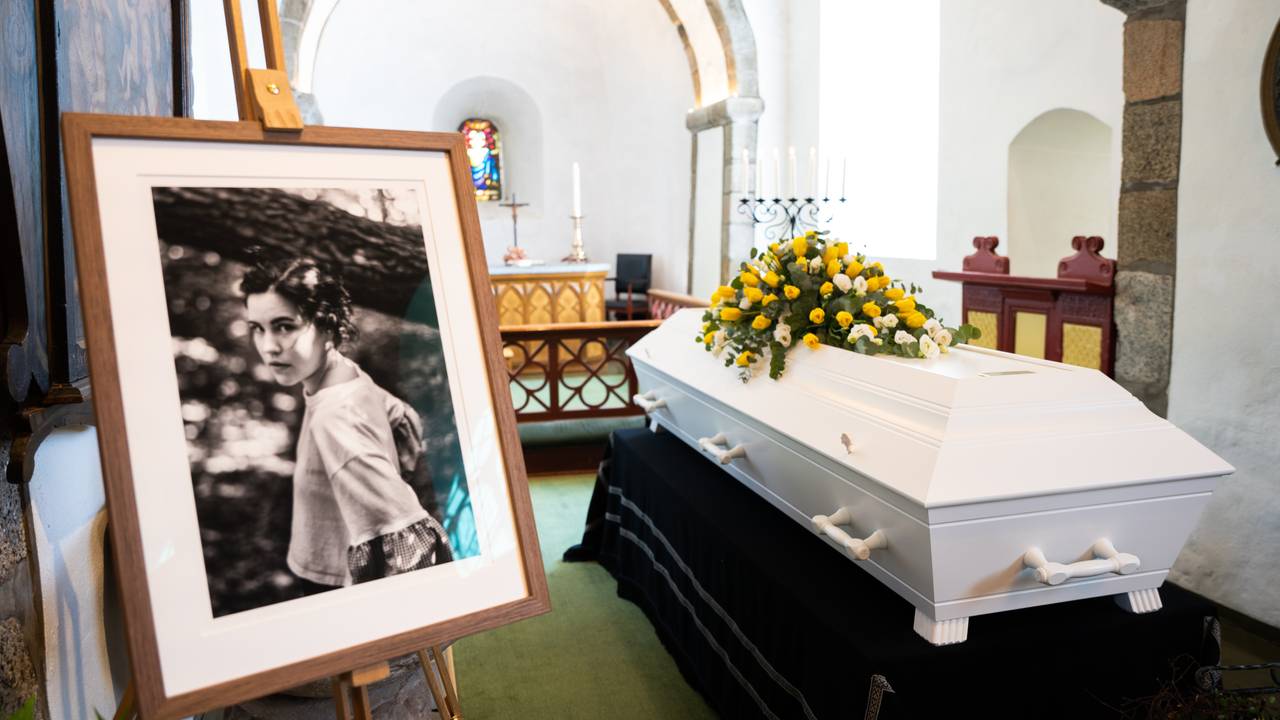 Bilde av Cecilie ved siden av en hvit kiste med masse gule blomster