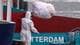 Yves Herman / REUTERS,NTB En person i smittevernutstyr hiver sengetøy i plastpose over rekka.
