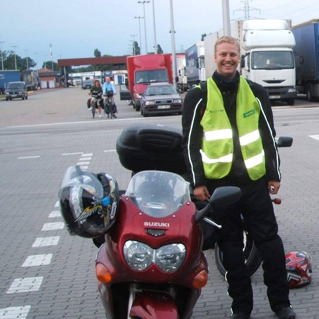 Ole Johnny Broholt Bakke har på seg refleksvest og poserer ved siden av en rød motorsykkel