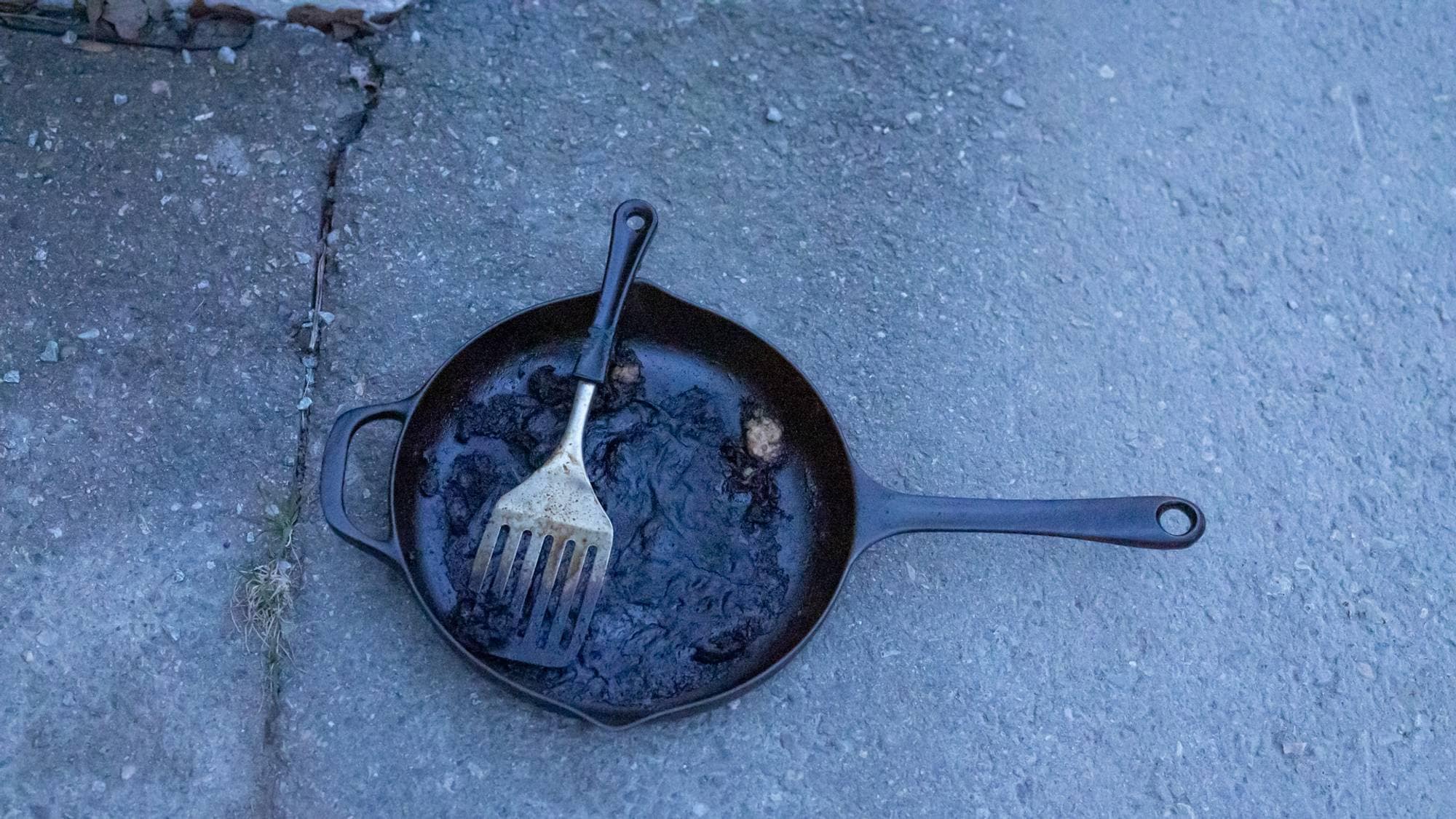 Mat på steikepanne var årsaken til den kraftige røykutviklingen. Bilde av en svart steikepanne med en delvis svidd steikespade