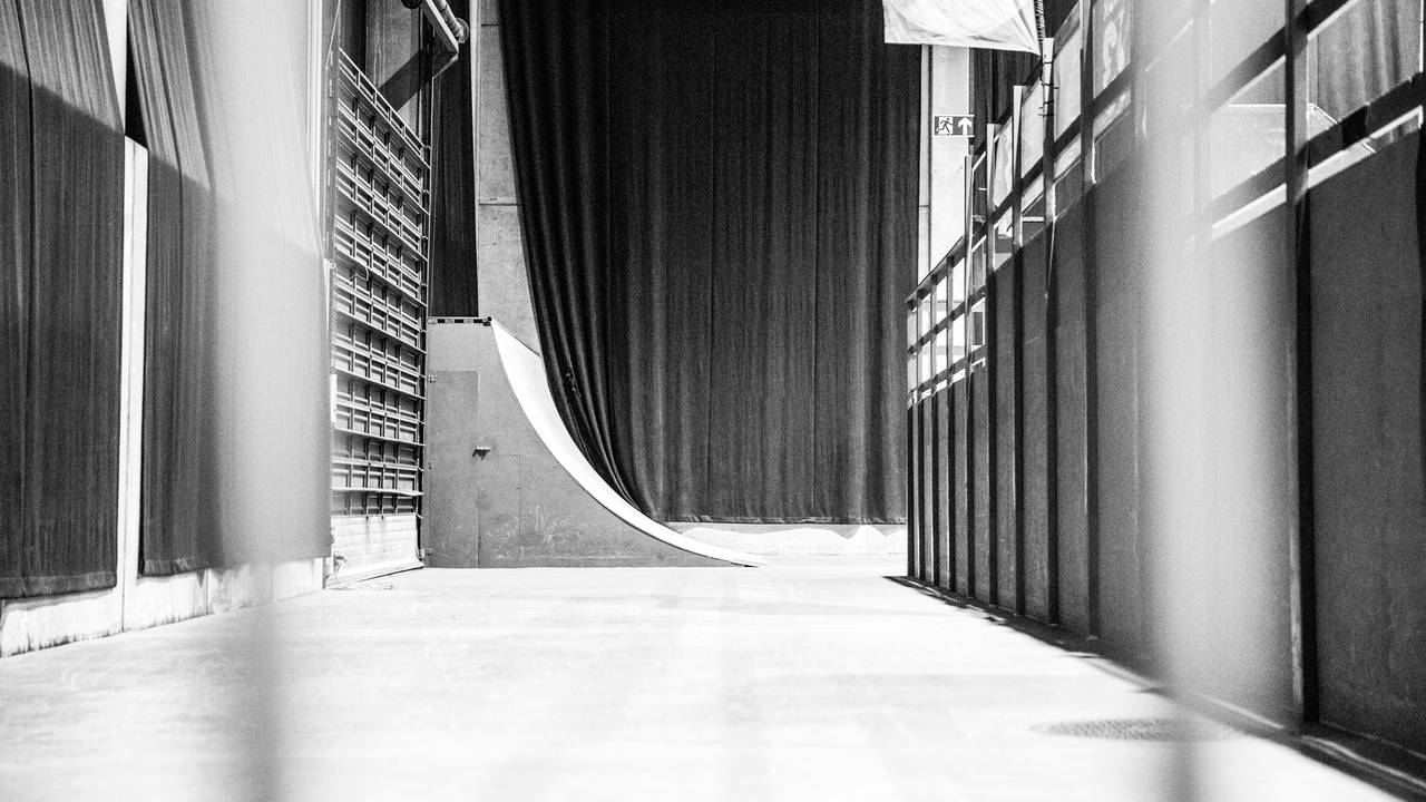 En tom skaterampe bak et gjerde.