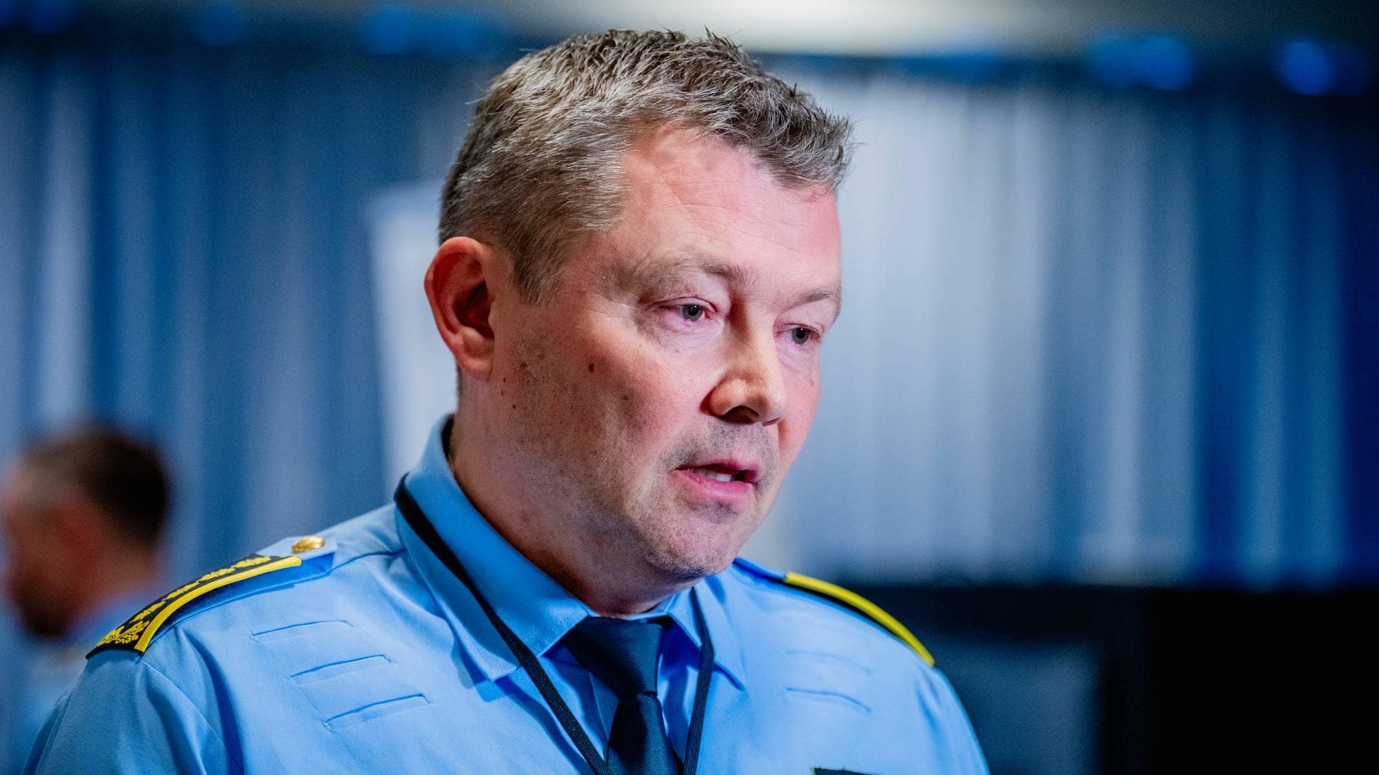 Portrett av en politimann i uniform. Han ser mot venstre side i bildet. (Bildebeskrivelsen er laget av en KI-tjeneste)