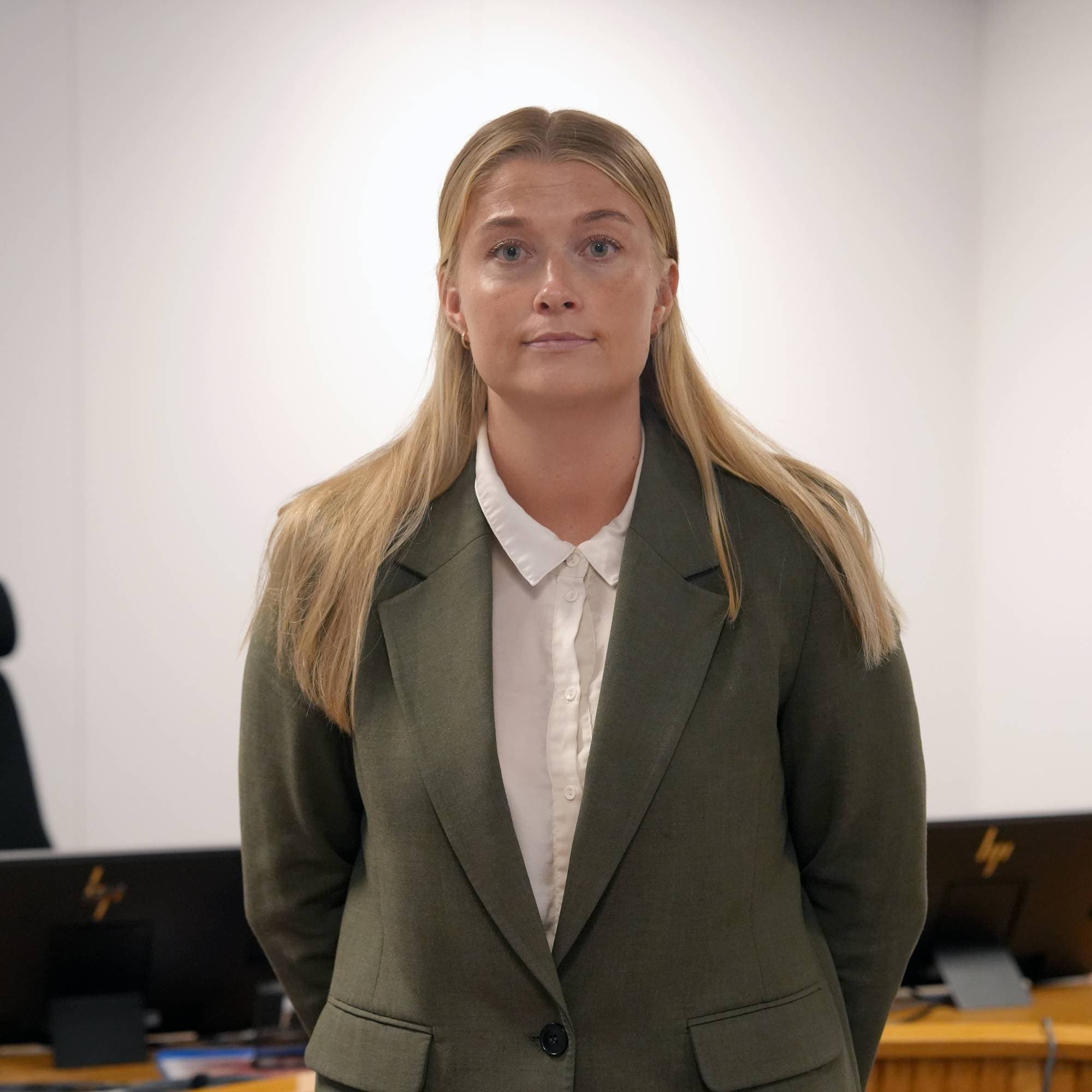 dame i grønn jakke ser på kamera