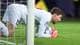 Foto: Terje Pedersen / NTB Keeper ligger på knærne og holder ballen foran mål på en fotballbane. (Bildebeskrivelsen er laget av en KI-tjeneste)
