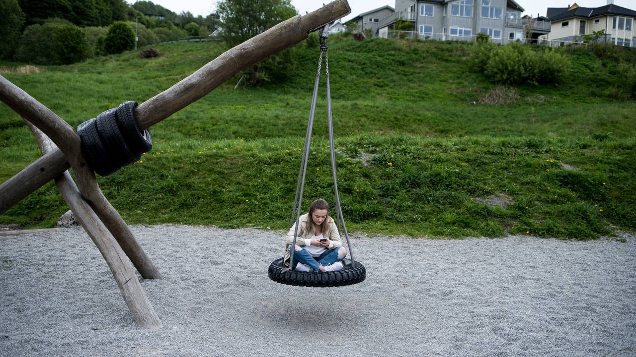 Bilde av Ingebjørg som sitter på en huske laget av et slags gummihjul. Husken er festet i et trestokk.