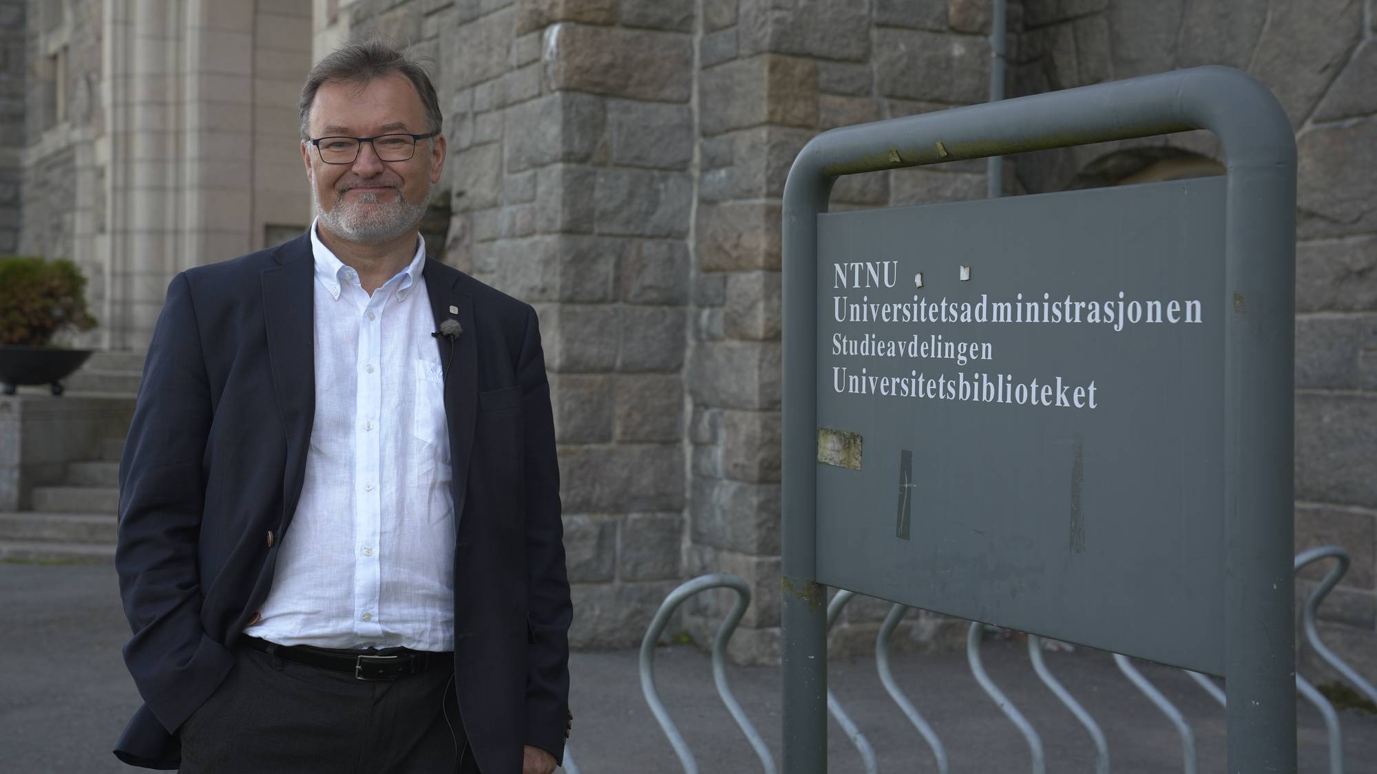 en mann som står ved siden av et skilt (Bildebeskrivelsen er laget av en KI-tjeneste)
