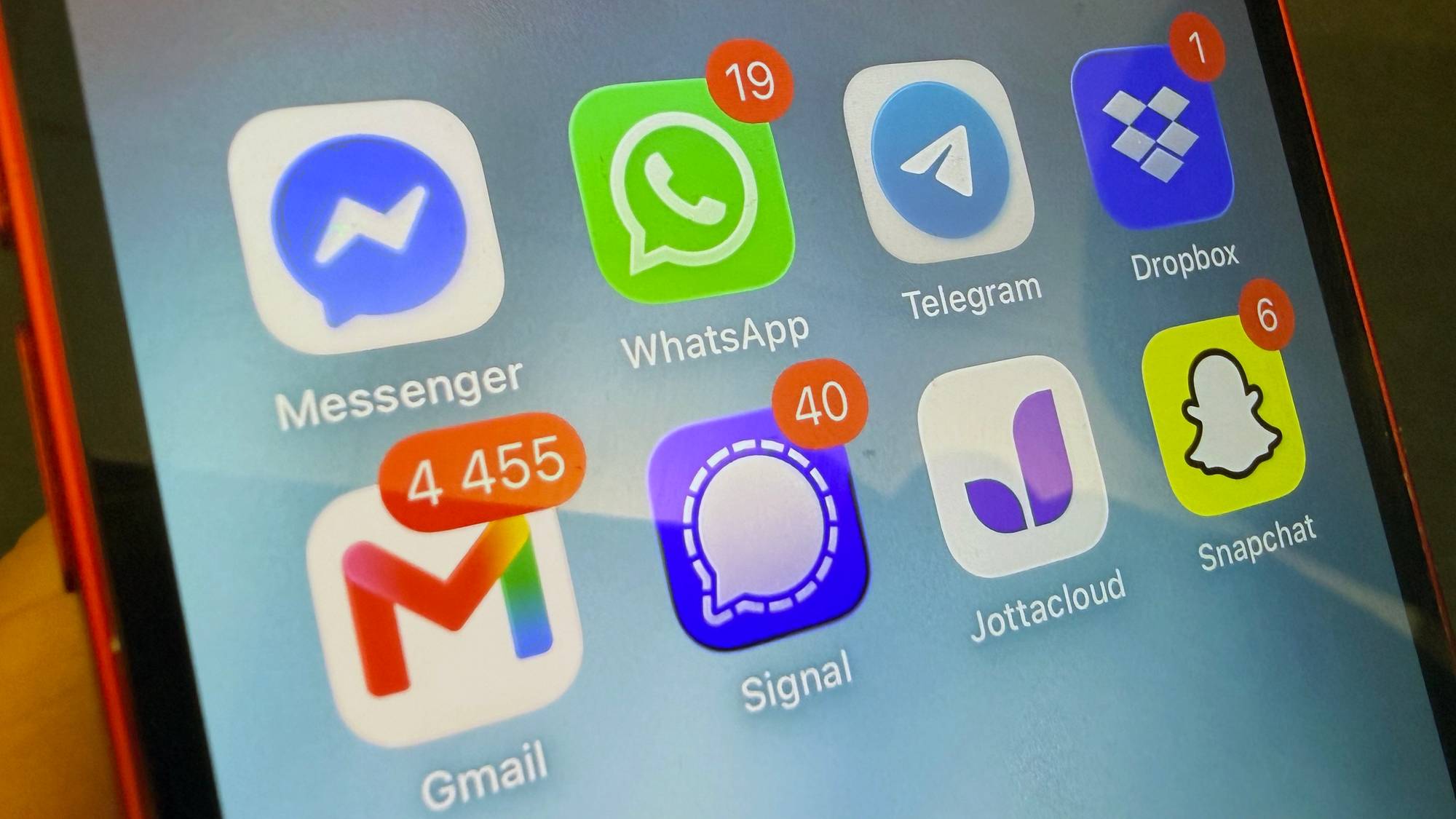 Nærbilde av en mobilskjerm med apper som Messenger, Gmail, Signal, Snapchat og Dropbox