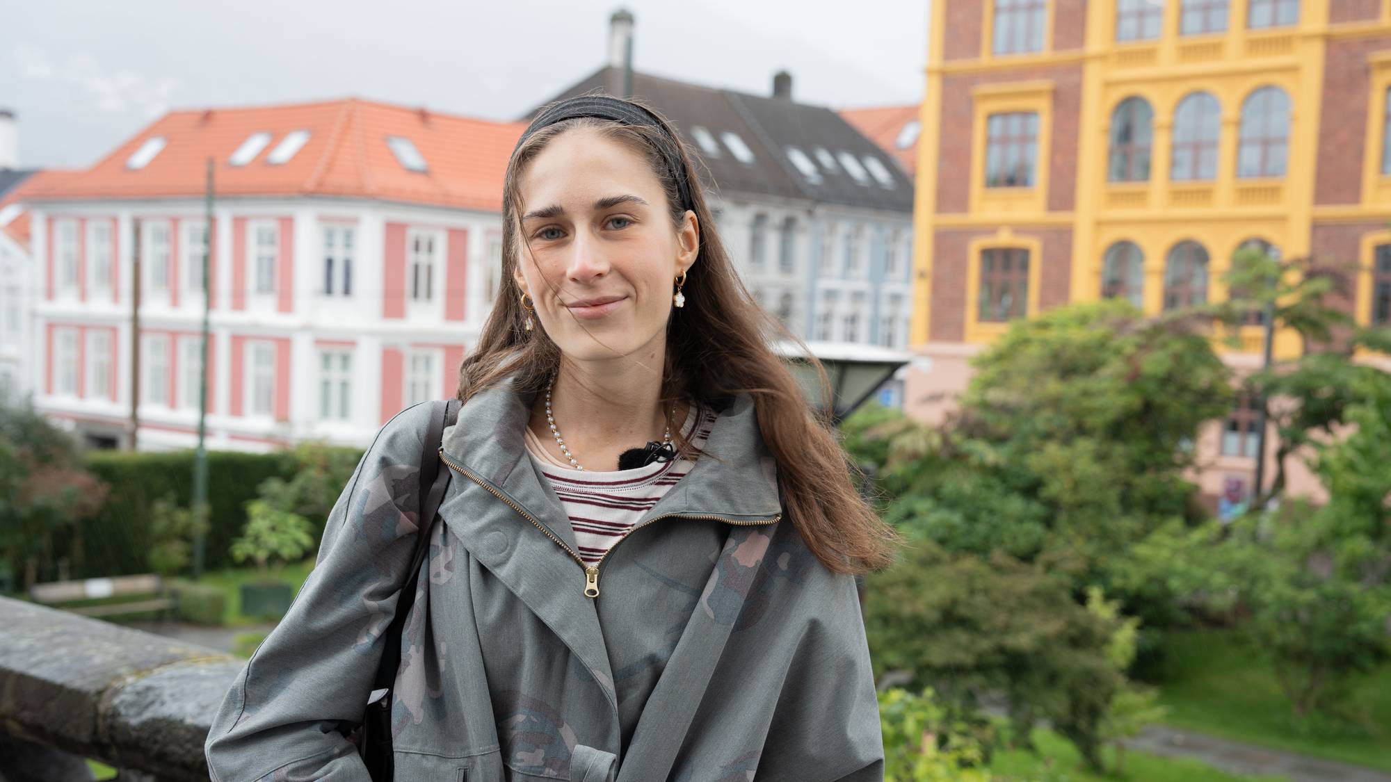 Kvinne med fargerike bygninger i bakgrunnen