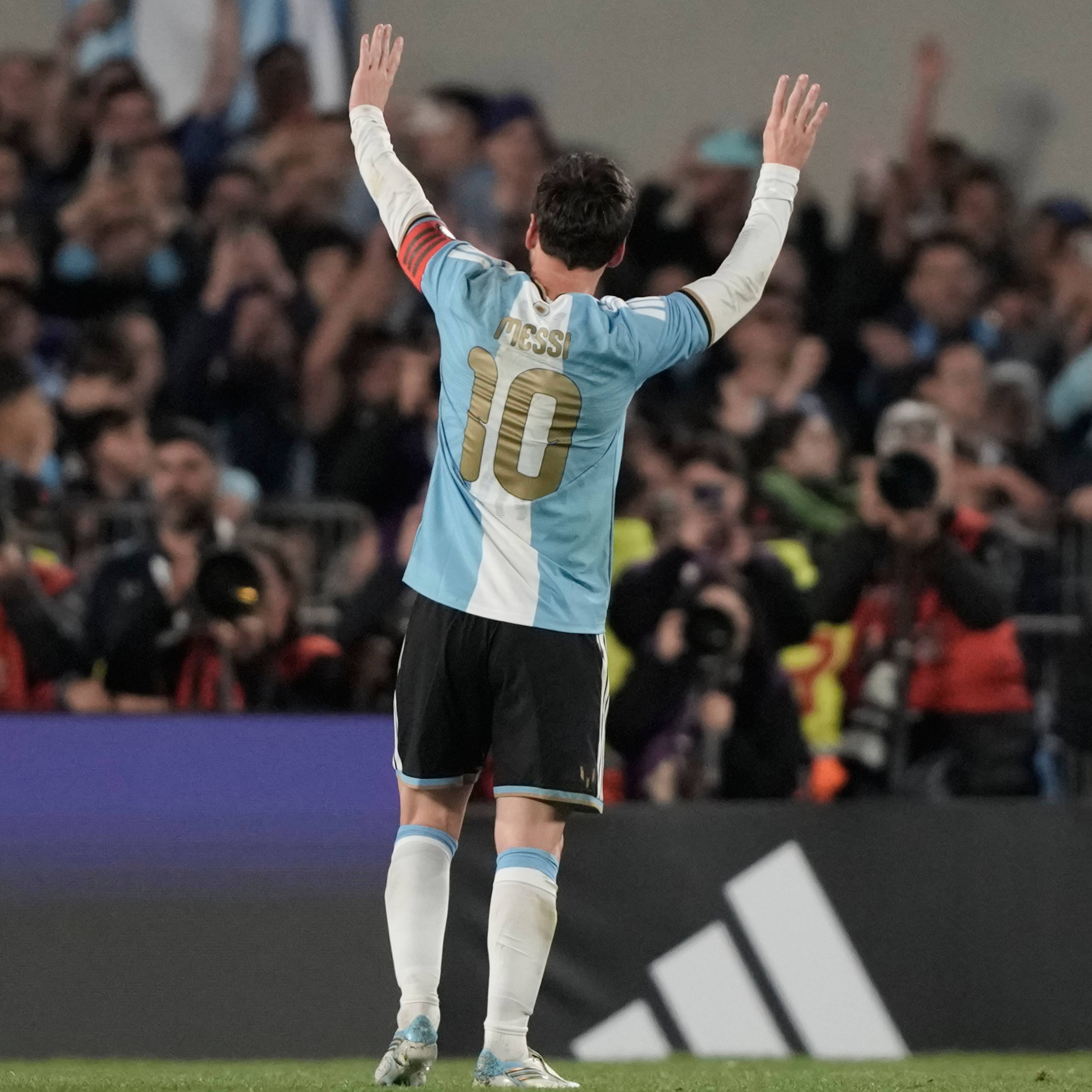 Lionel Messi feirer med hendene i været på en fotballbane foran publikum. (Bildebeskrivelsen er laget av en KI-tjeneste)