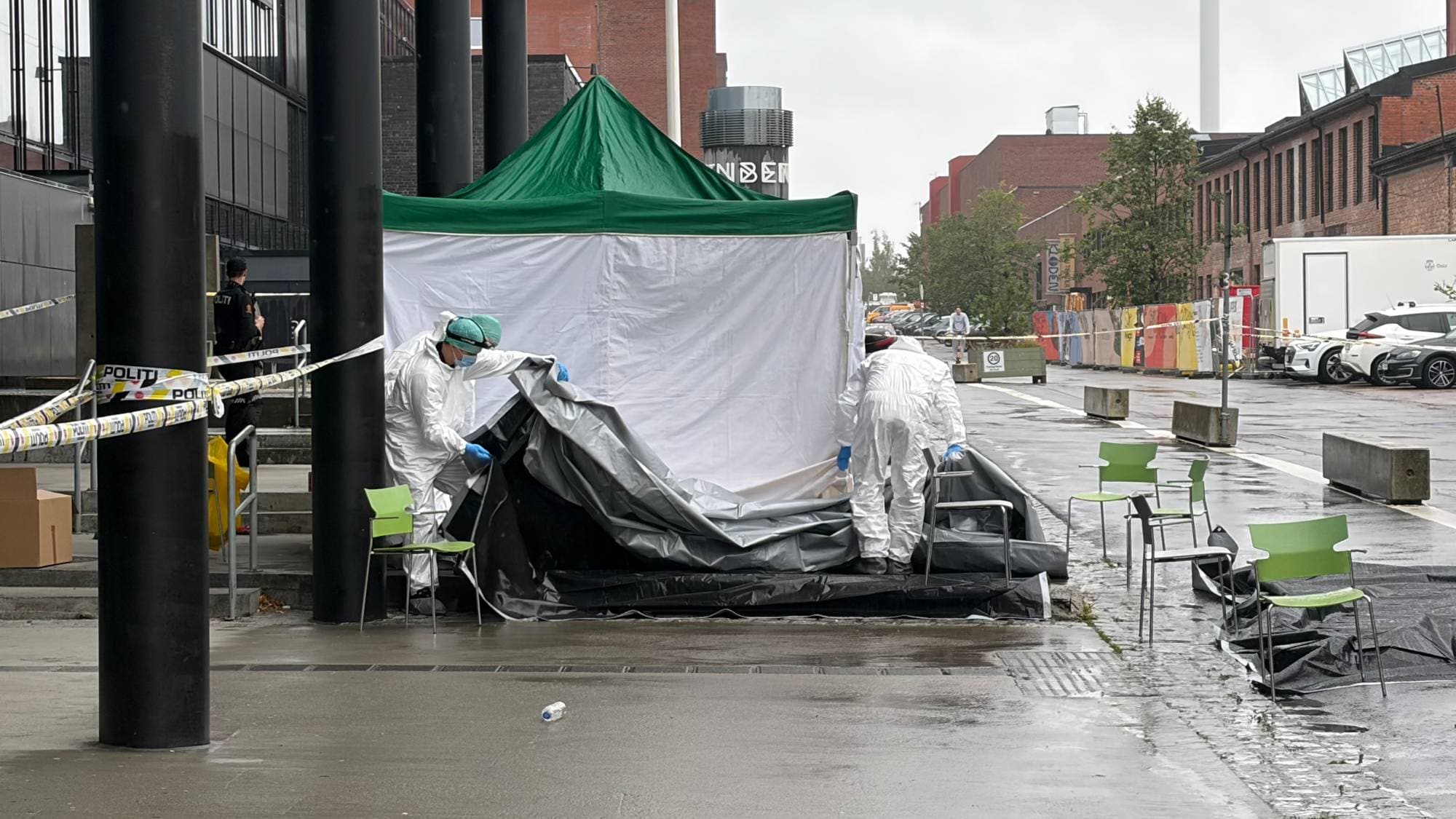 Et hvitt telt på et åsted med kjeledresskledde mennesker.
