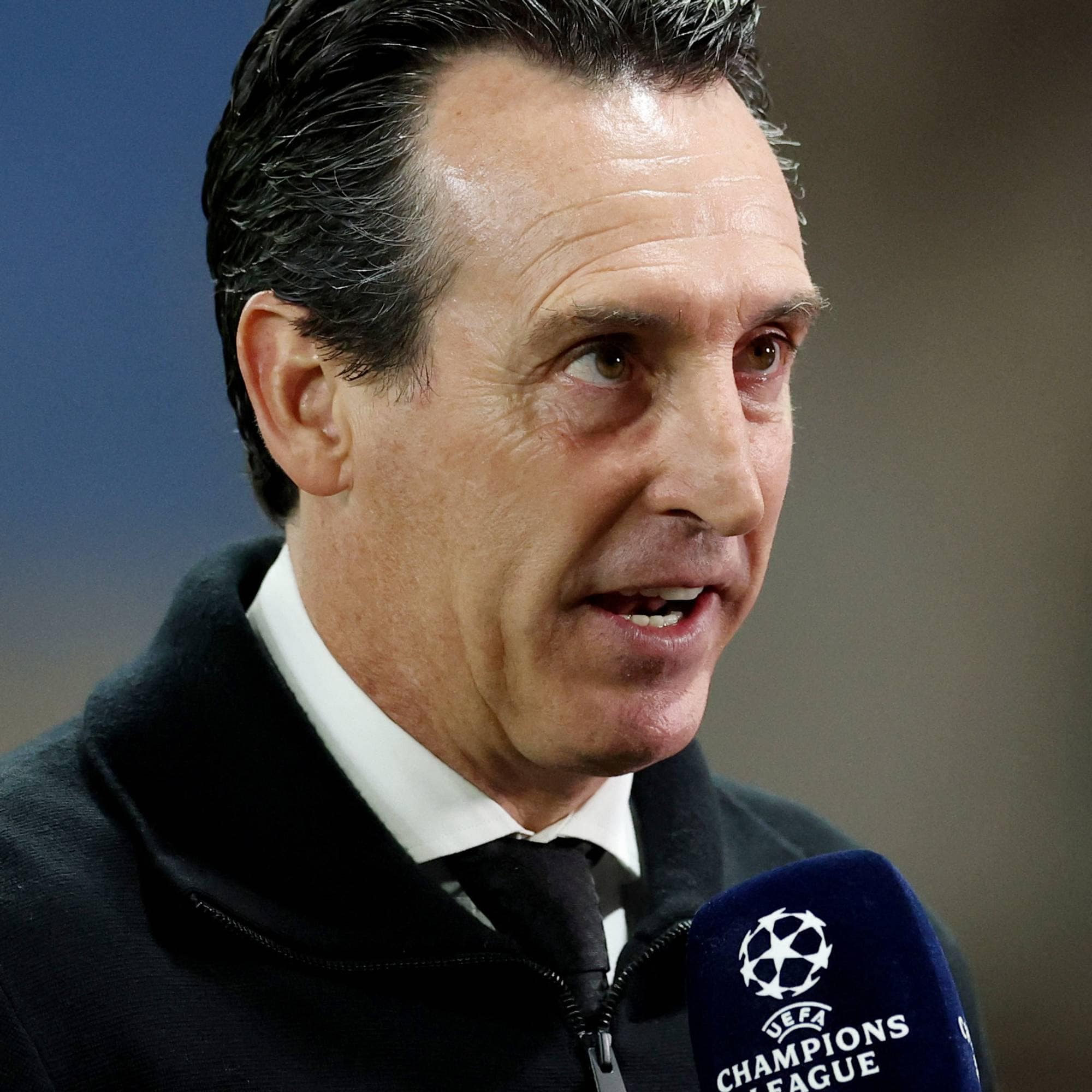 Fotballtrener Unai Emery blir intervjuet foran en mikrofon med Champions League-logo. (Bildebeskrivelsen er laget av en KI-tjeneste)