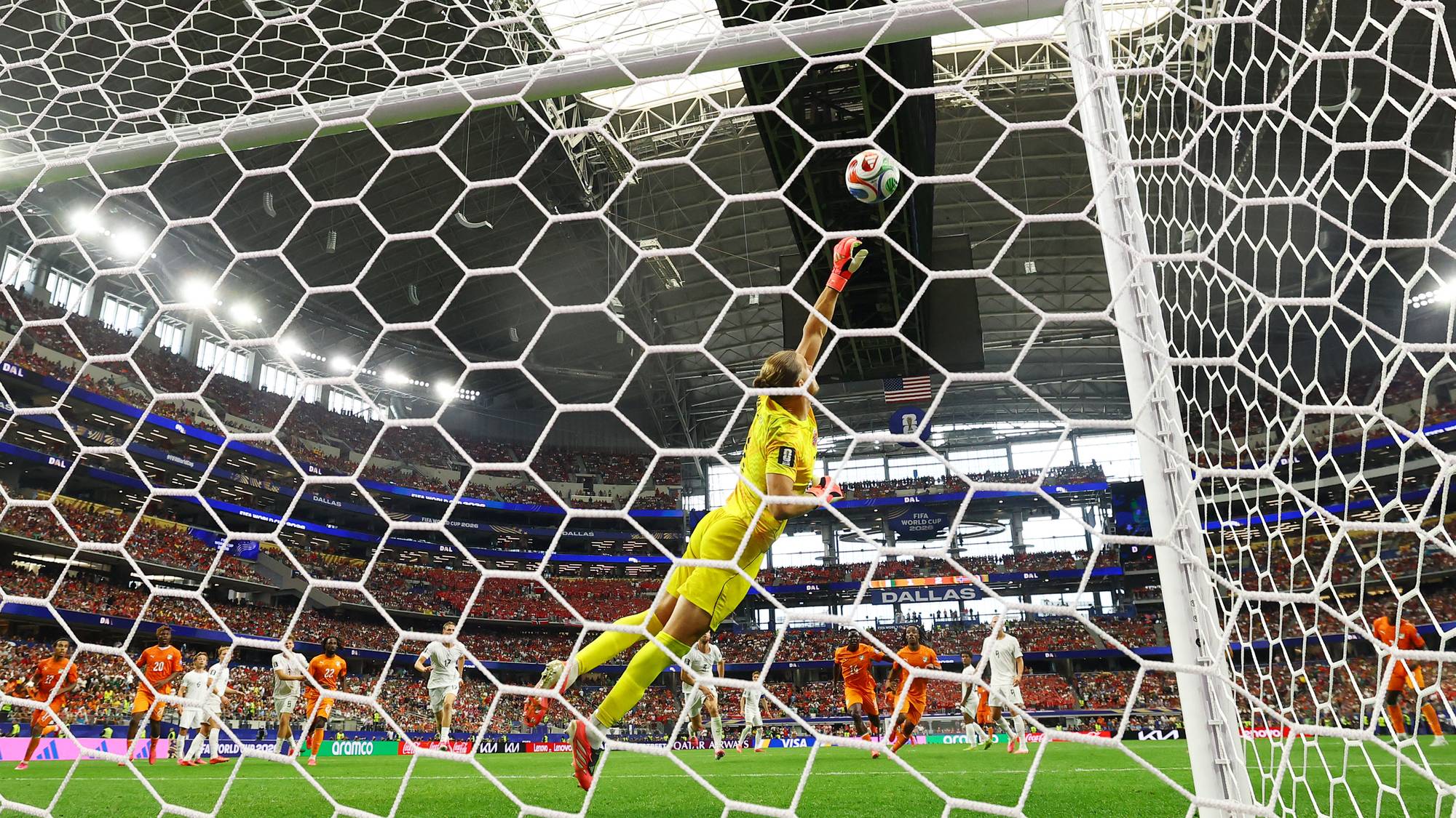 Keep viser en keeper i gul drakt som strekker seg etter en ball i et fotballmål. (Bildebeskrivelsen er laget av en KI-tjeneste)
