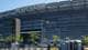 Bing Guan / REUTERS,NTB MetLife Stadium står i bakgrunnen. En mann med bag går forbi en rekke utedoer. Det er en bil med billetter. (Bildebeskrivelsen er laget av en KI-tjeneste)