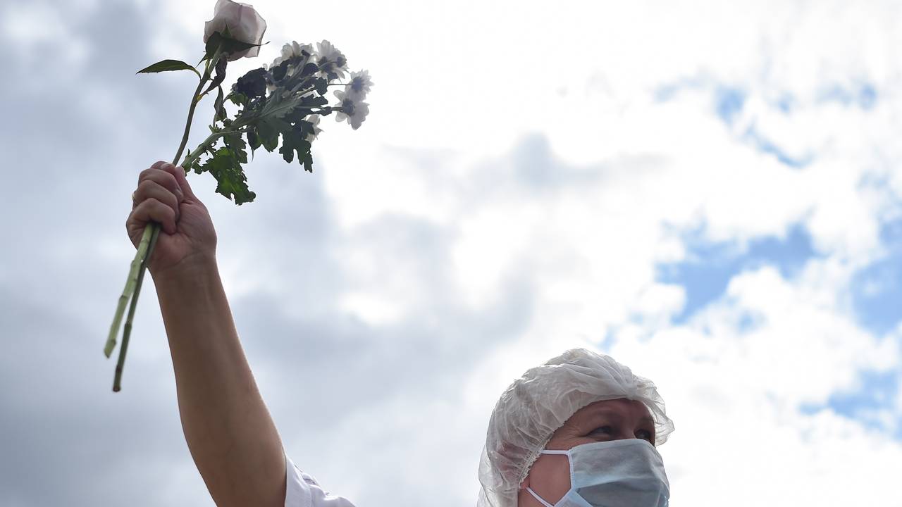 En sykehusarbeider demonstrerer med blomster i Minsk, Hviterussland.