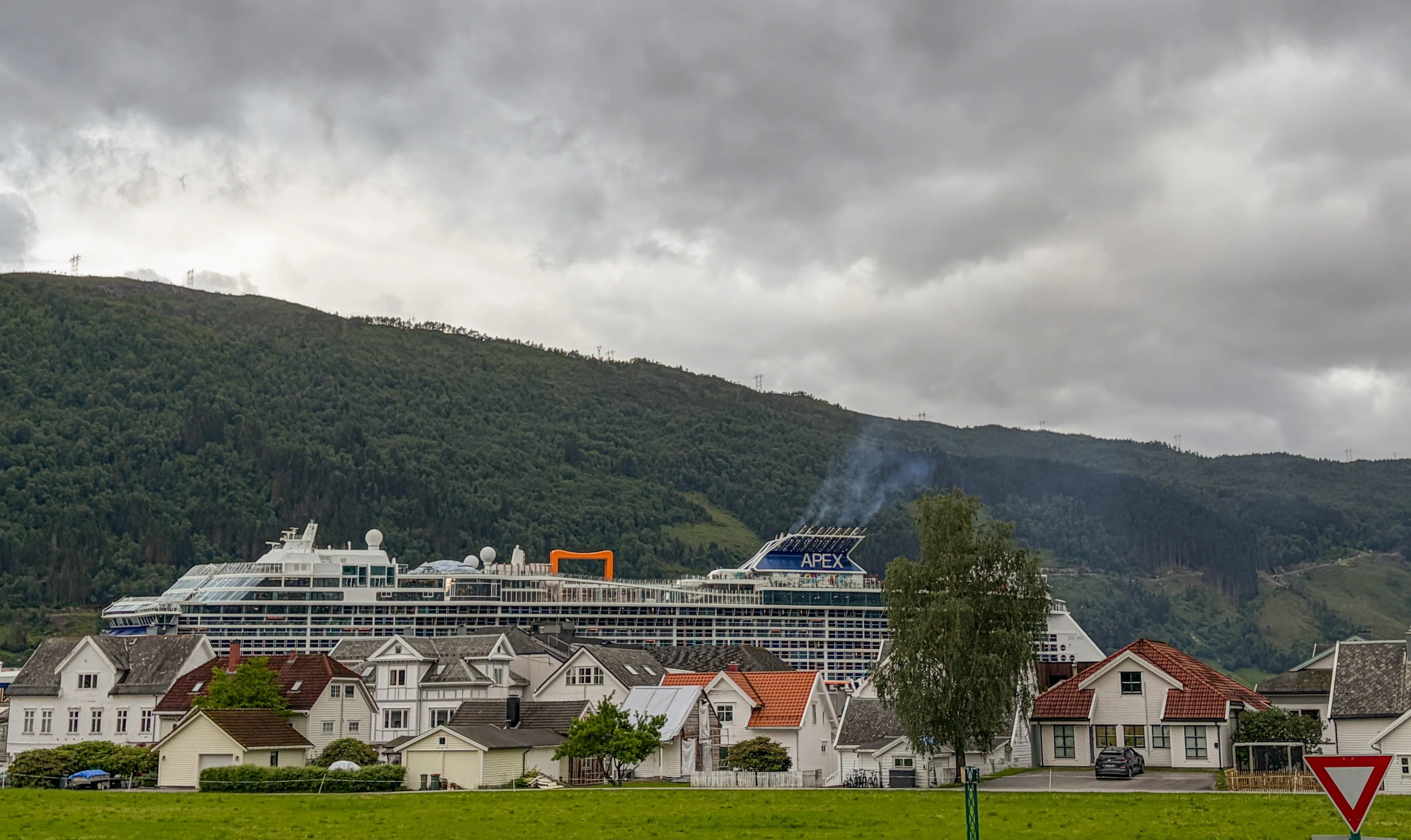 en gruppe hus med et fjell i bakgrunnen (Bildebeskrivelsen er laget av en KI-tjeneste)
