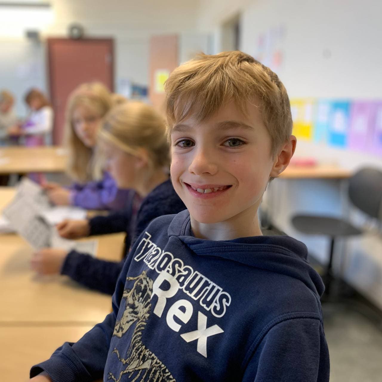 Johannes sitter ved pulten i klasserommet.
