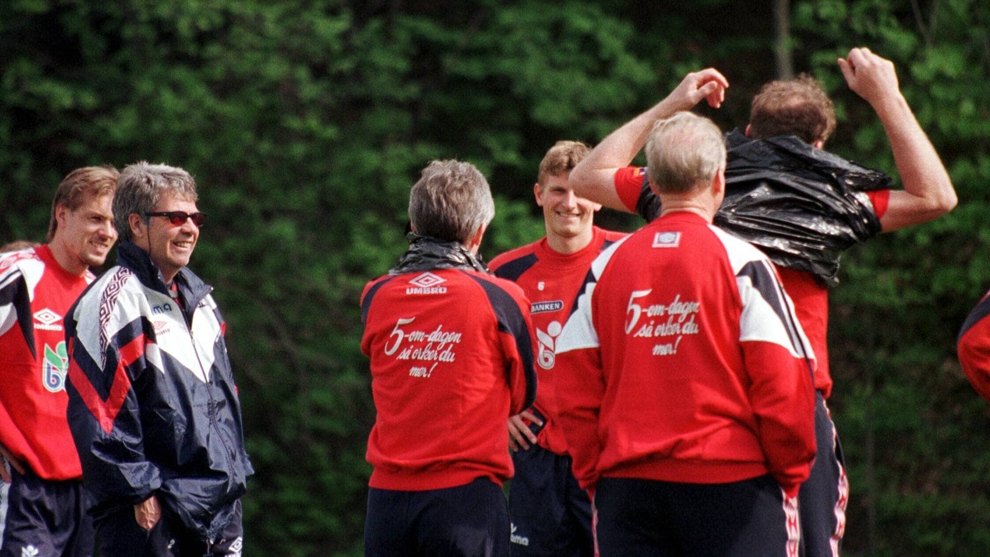 Det norske fotballandslaget smiler av at landslagslegen må ta på seg en søppelsekk. 