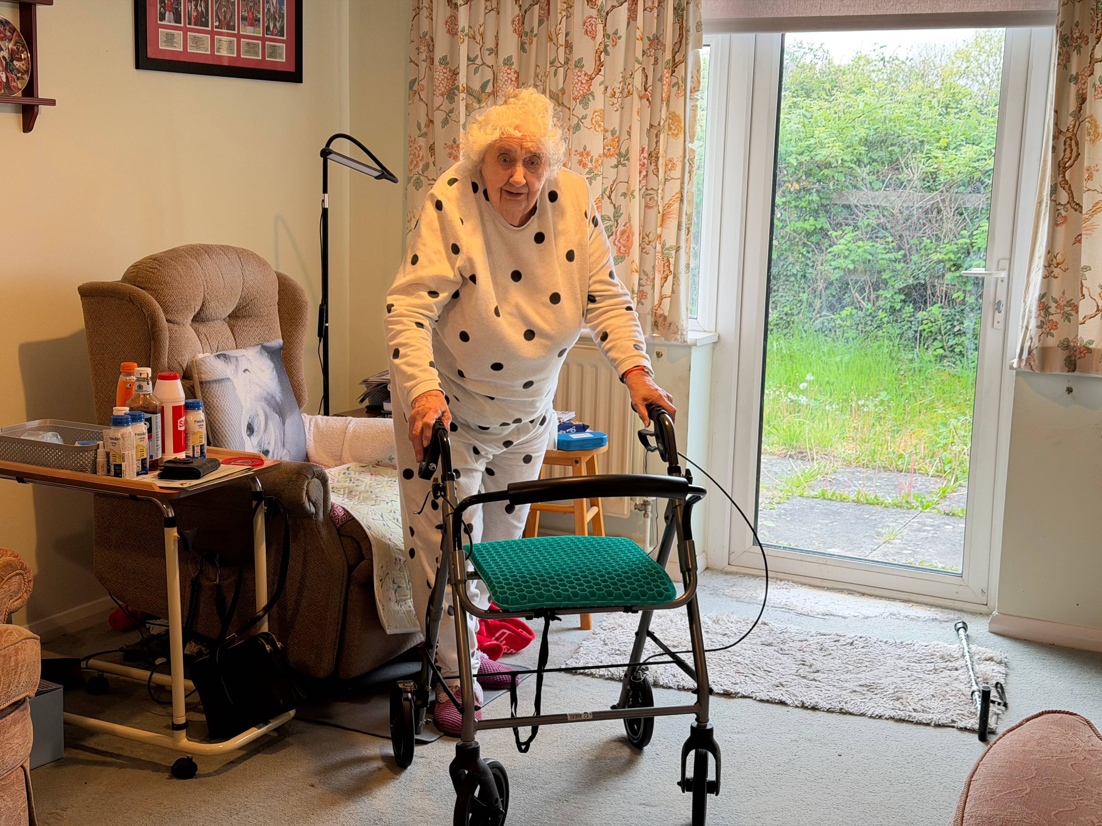 En eldre kvinne går med en rullator