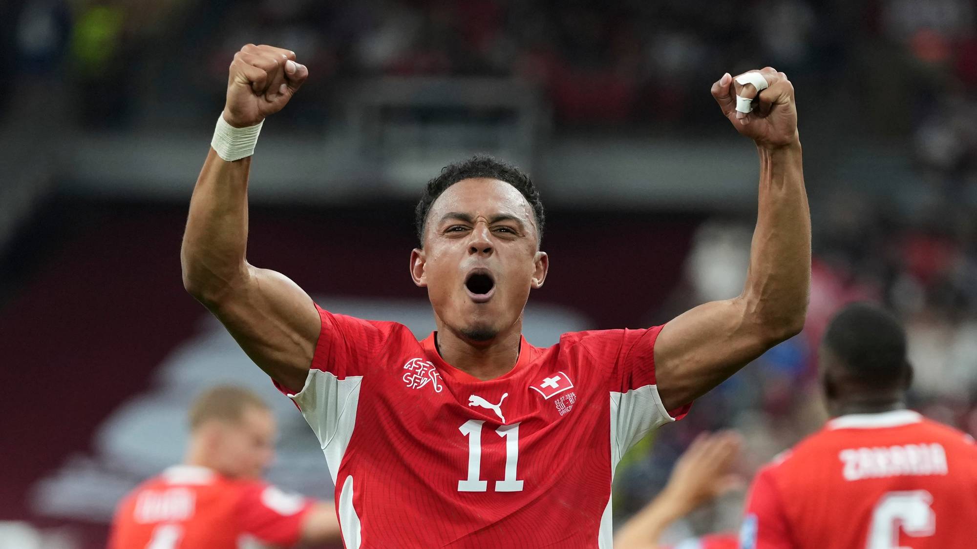 Sveitsisk fotballspiller jubler med armene hevet etter scoring i en landskamp. (Bildebeskrivelsen er laget av en KI-tjeneste)