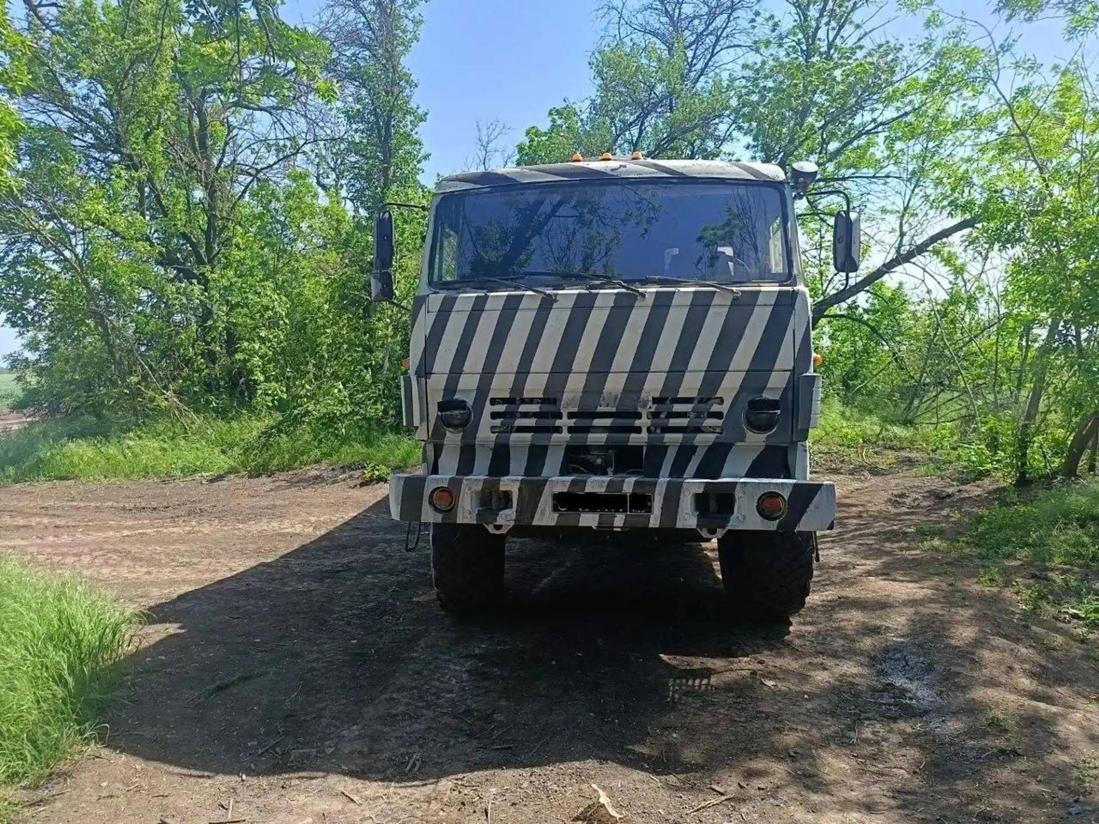 Bilder av russiske militære kjøretøyer malt med sorte og hvite striper.